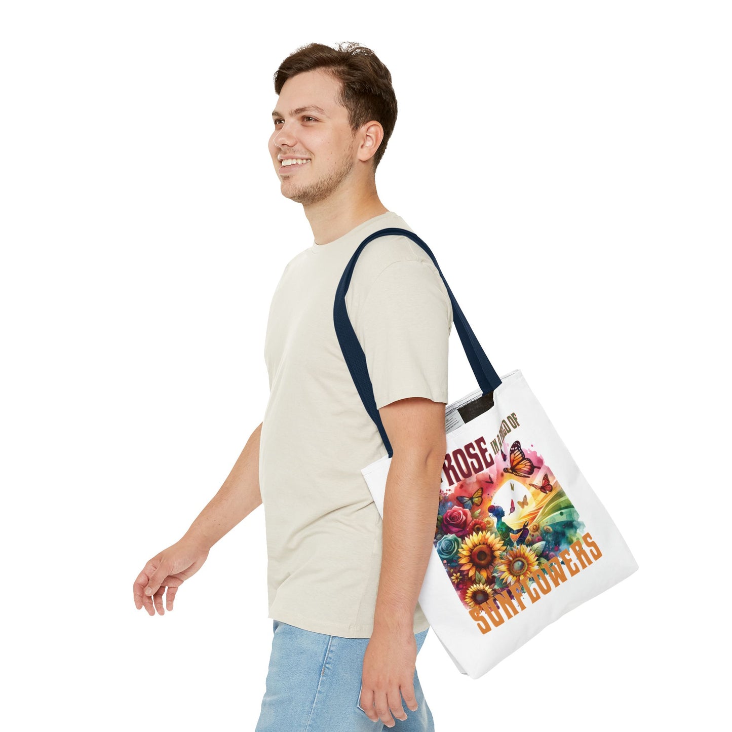 Man holding the Be the Rose in a Field of Sunflowers Tote Bag, showcasing flower and butterfly design, highlighting its nature-inspired and uplifting style.