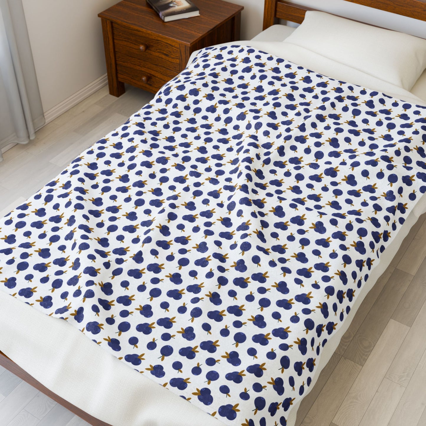 Plush Blanket - Blueberry Pattern draped over a bed, showcasing its cozy and inviting design, ideal for adding a touch of comfort and style to any bedroom setting.
