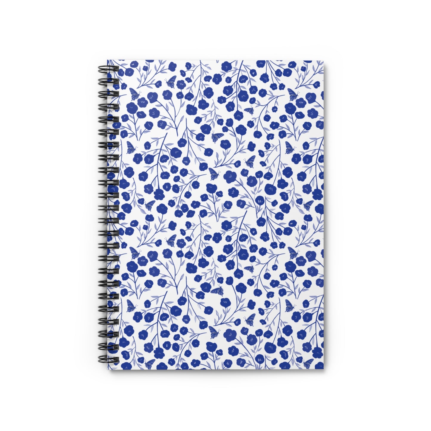 Floral Spiral Notebook featuring a white cover with a pattern of blue blossoms and butterflies, combining style and functionality for creative expression. Perfect for jotting notes or sketching ideas.