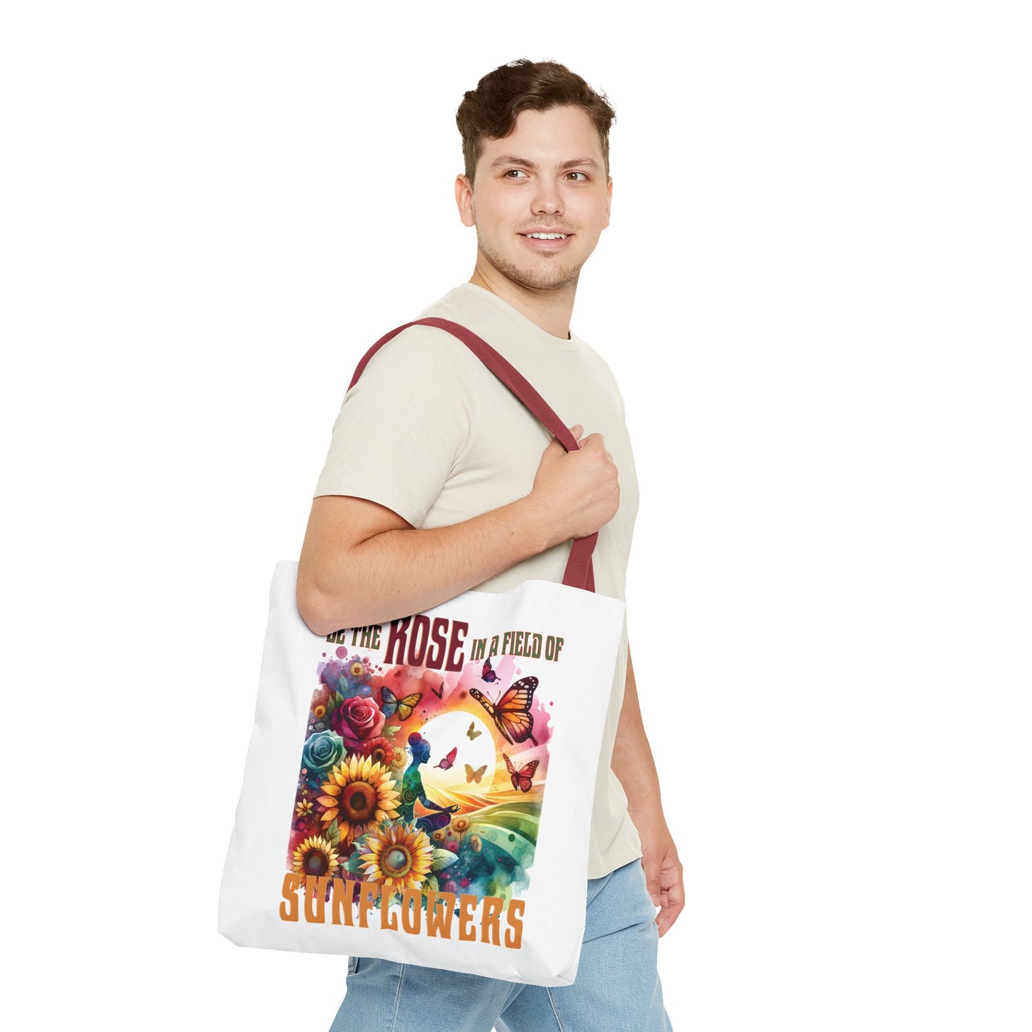 Man smiling while holding the Be the Rose in a Field of Sunflowers tote bag, showcasing its flower and butterfly design, ideal for everyday use.