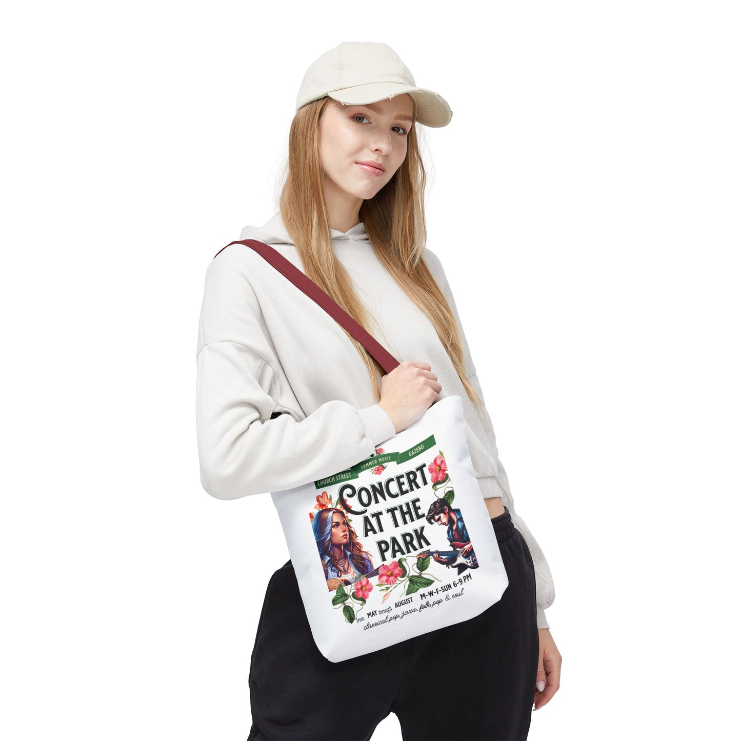 Woman holding the Concert At the Park Tote Bag, showcasing its lively design ideal for music lovers and outdoor activities, emphasizing its ample storage and durability.