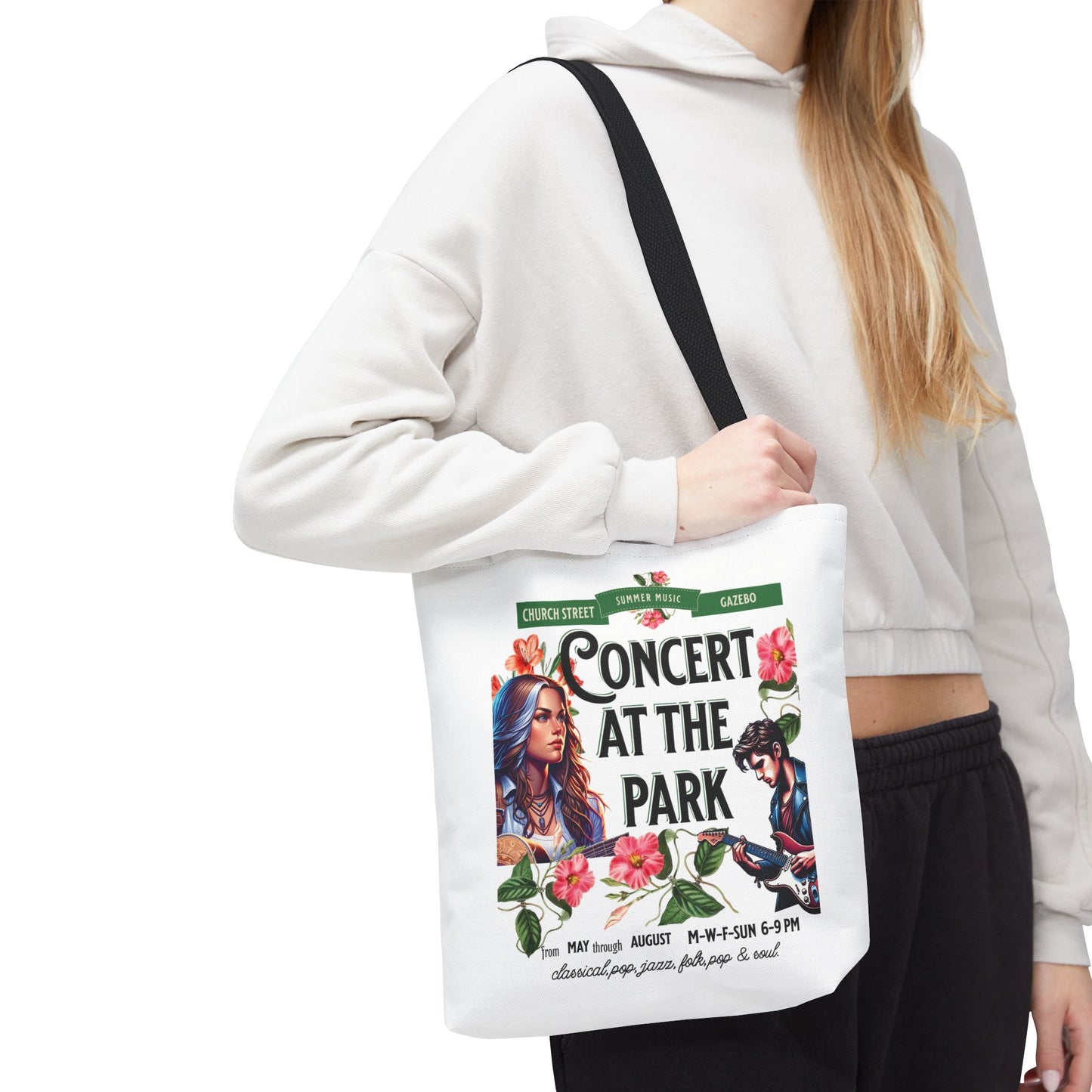 Concert At the Park Tote Bag featuring a lively concert design, held by a woman, ideal for music lovers and outdoor activities.