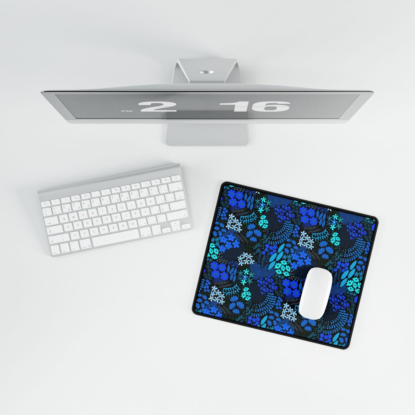 Blue Floral Desk Mat displayed in a minimalist setup, featuring vibrant hand-drawn blue and teal florals. Complements a sleek silver monitor, white keyboard, and mouse, adding elegance and positivity to your workspace.