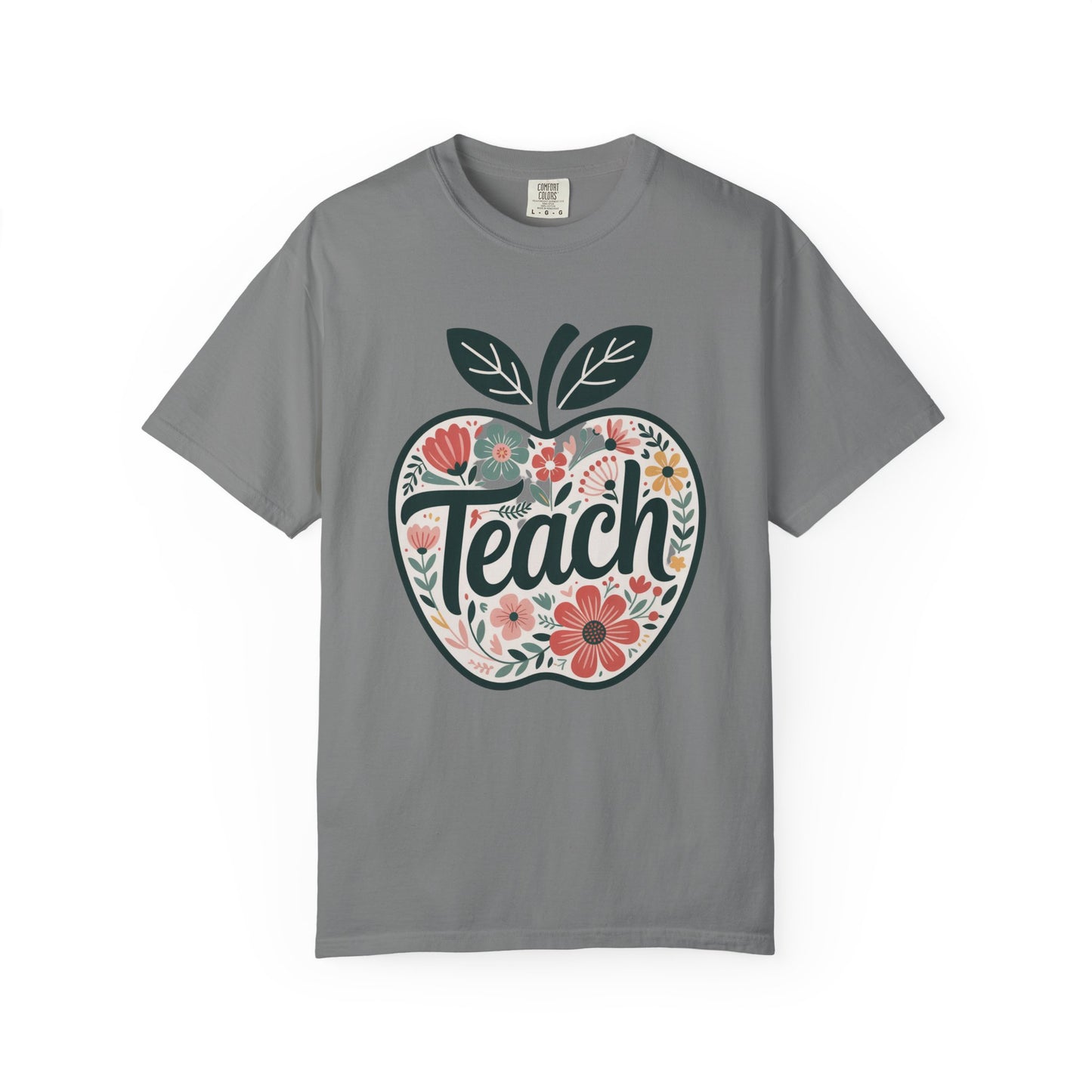 Floral Apple TEACH T-shirt features a hand-drawn, pastel floral apple with TEACH in textured script, ideal for educators. Cozy, garment-dyed fabric enhances comfort and style.