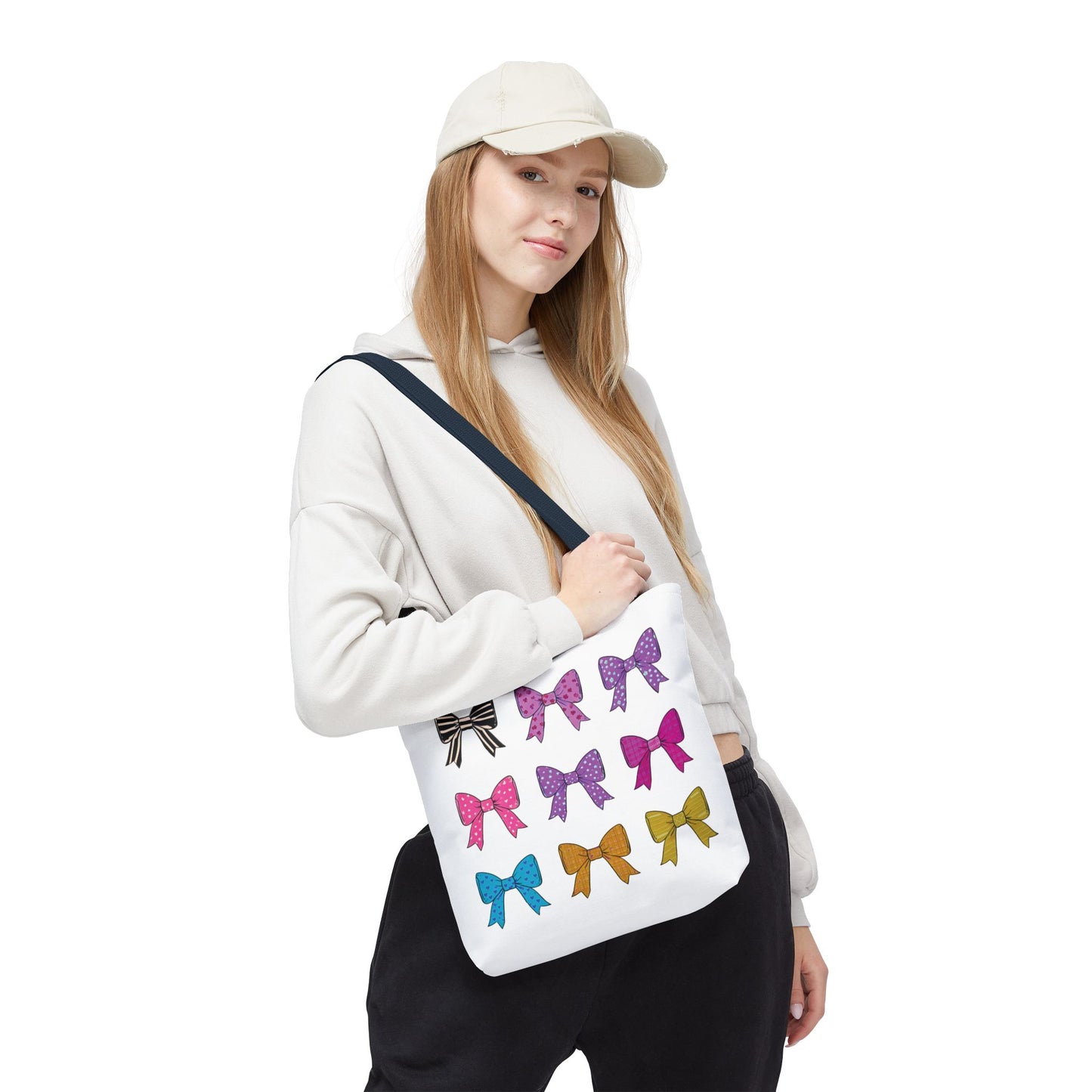 Woman holding the Bows Ribbons Tote Bag, featuring playful bow prints. A stylish, durable accessory ideal for everyday use, blending fashion and functionality.
