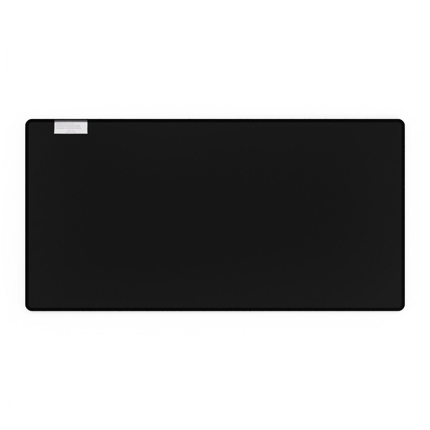 Blue Floral Desk Mat featuring hand-drawn blue florals on a black surface, with rounded corners and stitched edges. A white care label is affixed near the upper-left corner, enhancing workspace elegance.