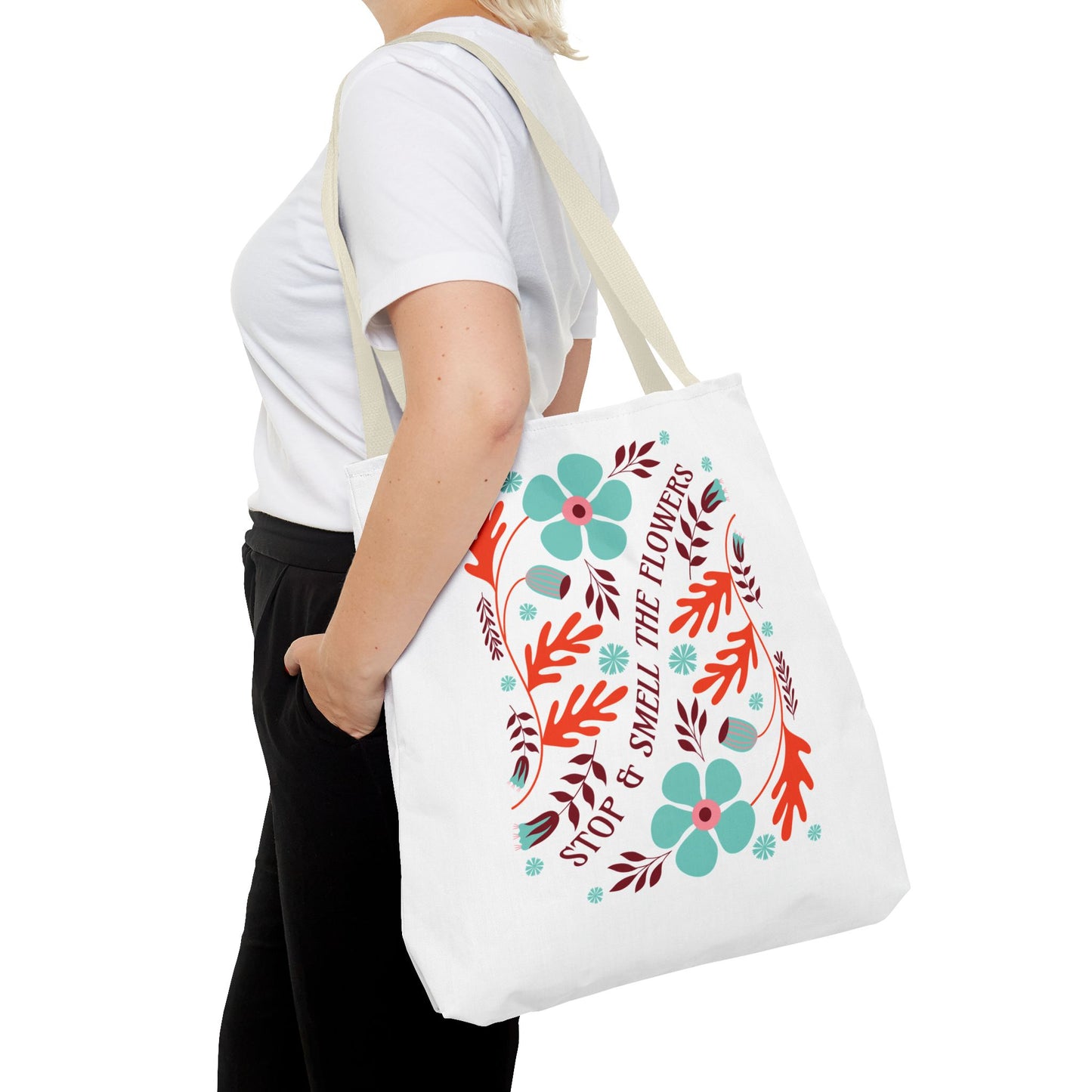 Woman holding the Stop and Smell The Flowers Tote Bag, featuring floral designs, ideal for carrying essentials and spreading positivity, from FireBrook Essentials.