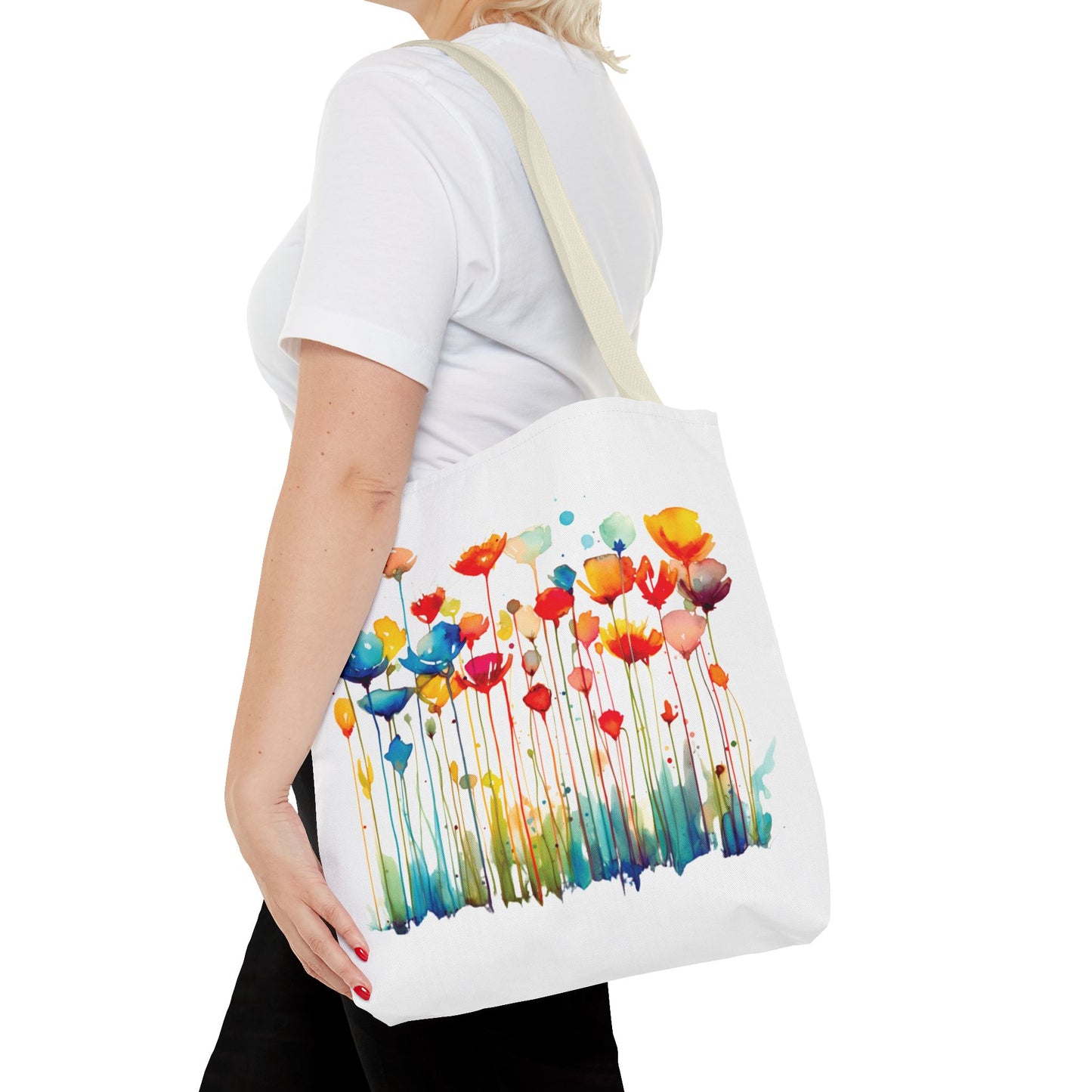 Woman holding a Watercolor Floral Tote Bag adorned with flower patterns, ideal for versatile use, combining functionality and style with reinforced handles for durability.
