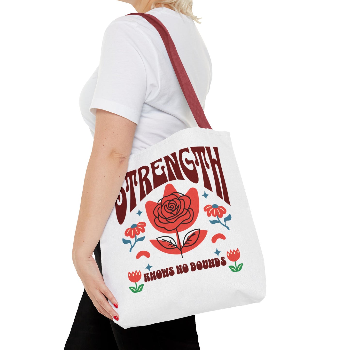 Strength Knows No Bounds Tote Bag carried by a woman, featuring a red rose design, ideal for everyday use and gifting, from FireBrook Essentials.