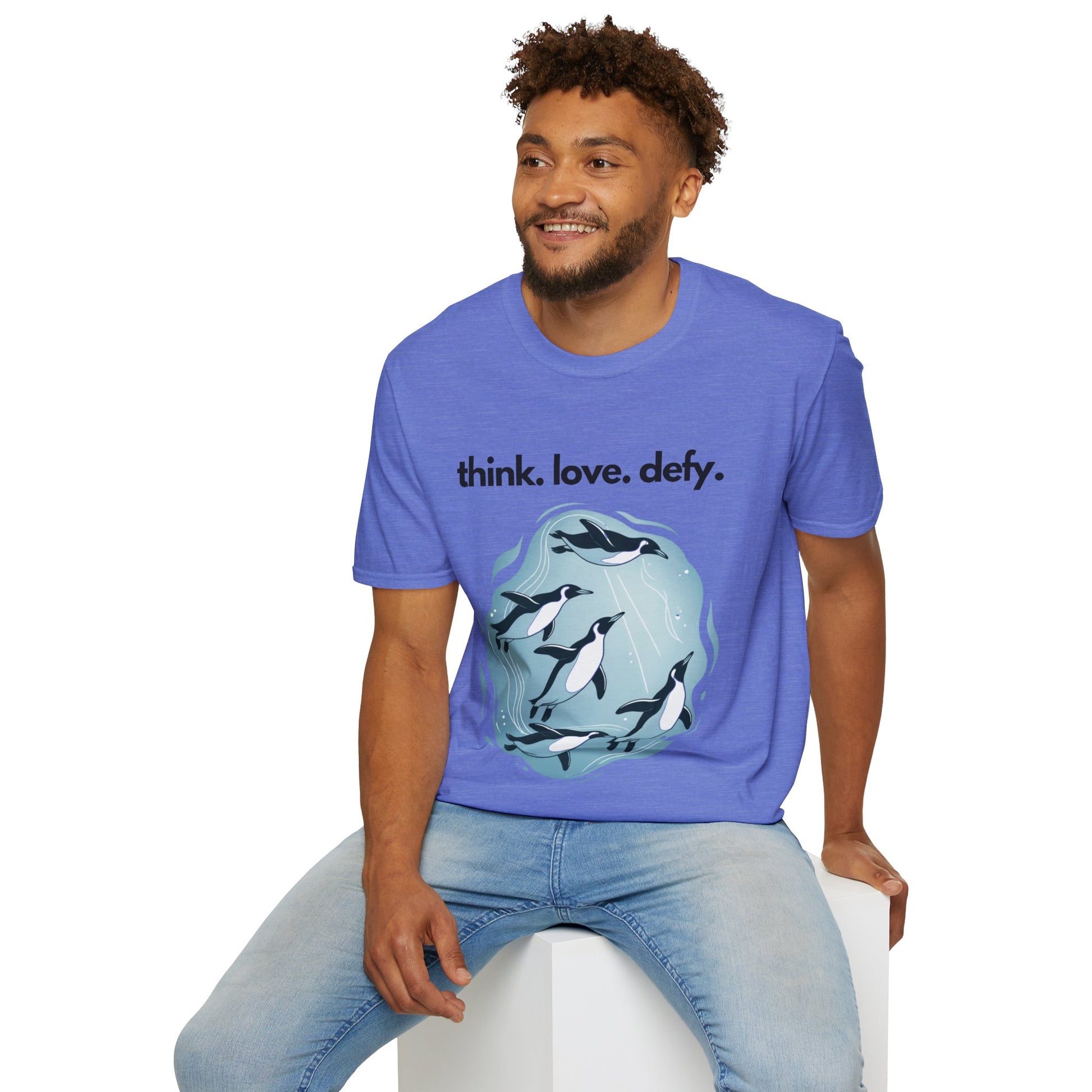 Think Love Defy Penguin Animal Nature Gildan Unisex T-Shirt, showcasing man seated, wearing this eco-friendly, penguin-themed shirt, ideal for nature lovers and casual outings, embodying comfort and unique design.