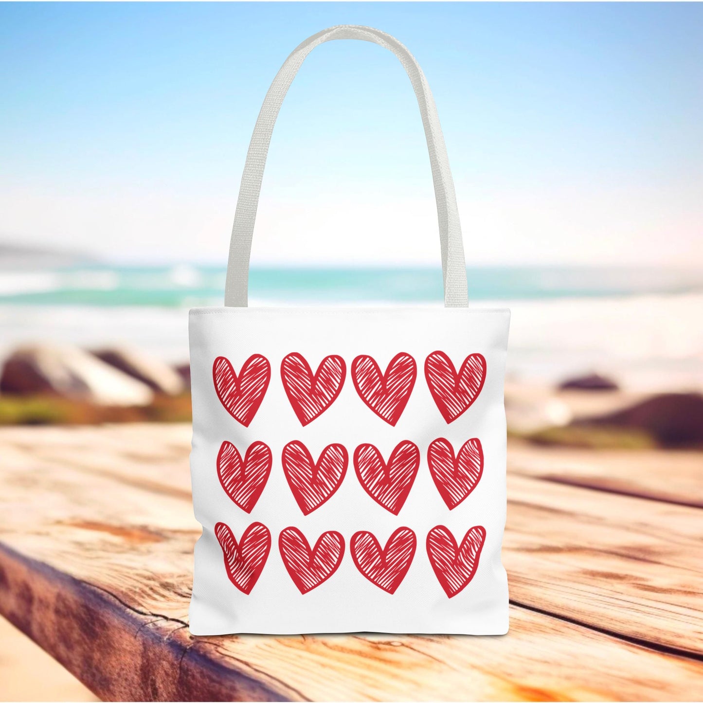 Hearts Tote Bag featuring red heart patterns, embodying FireBrook Designs' joyful and uplifting style. Ideal for adding charm to everyday outfits with its spacious design and durable polyester body.