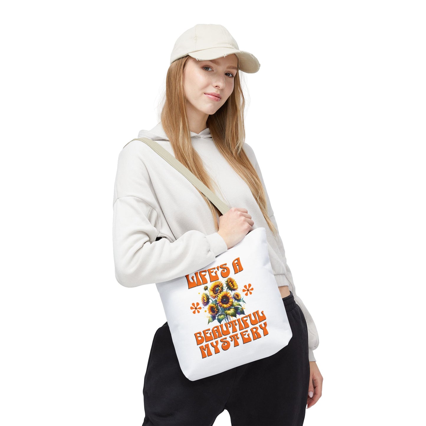 Woman in a white sweatshirt holding the Life's A Beautiful Mystery tote bag, highlighting its durable design and sense of adventure.