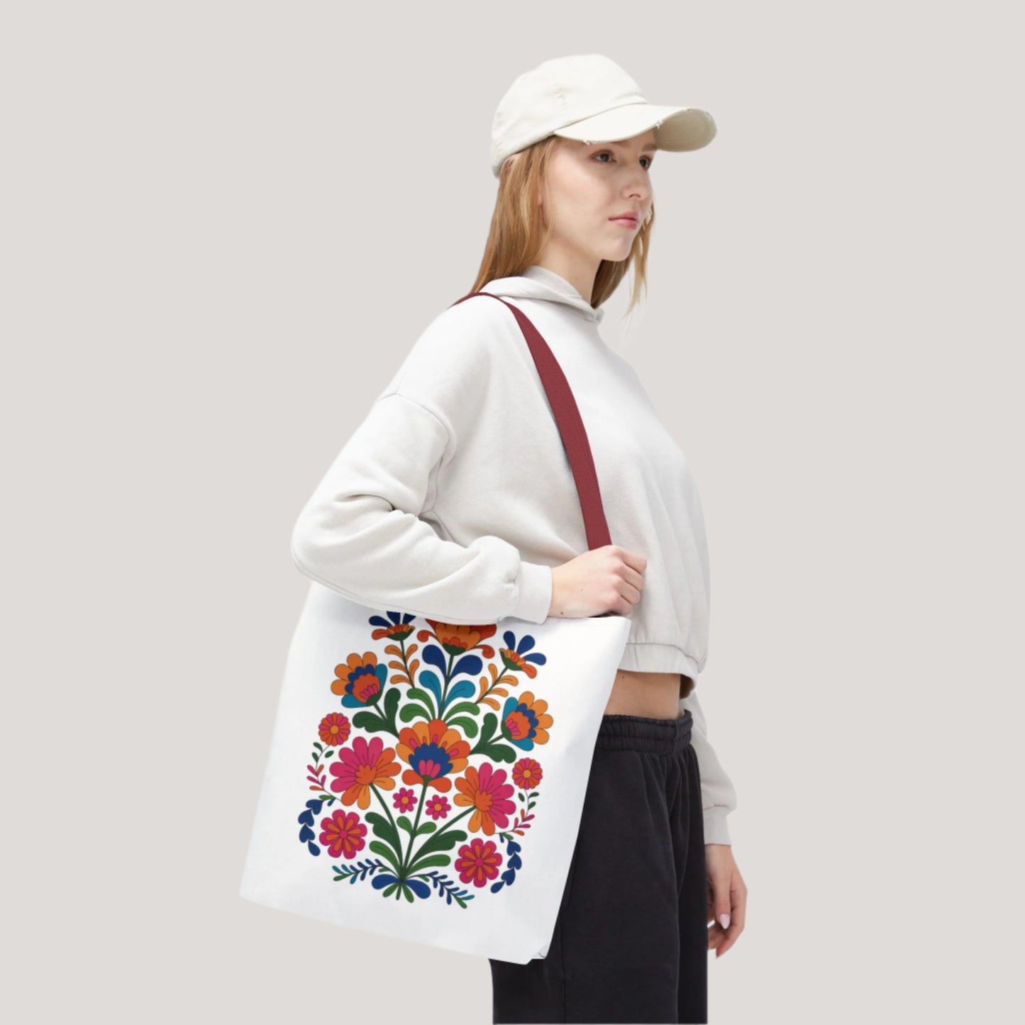 Red Folk-Art Floral Tote Bag featuring vibrant, organic floral illustrations in red tones with bold, delicate flowers, and green leaves. Ideal for carrying essentials with style and durability. Available in multiple sizes.