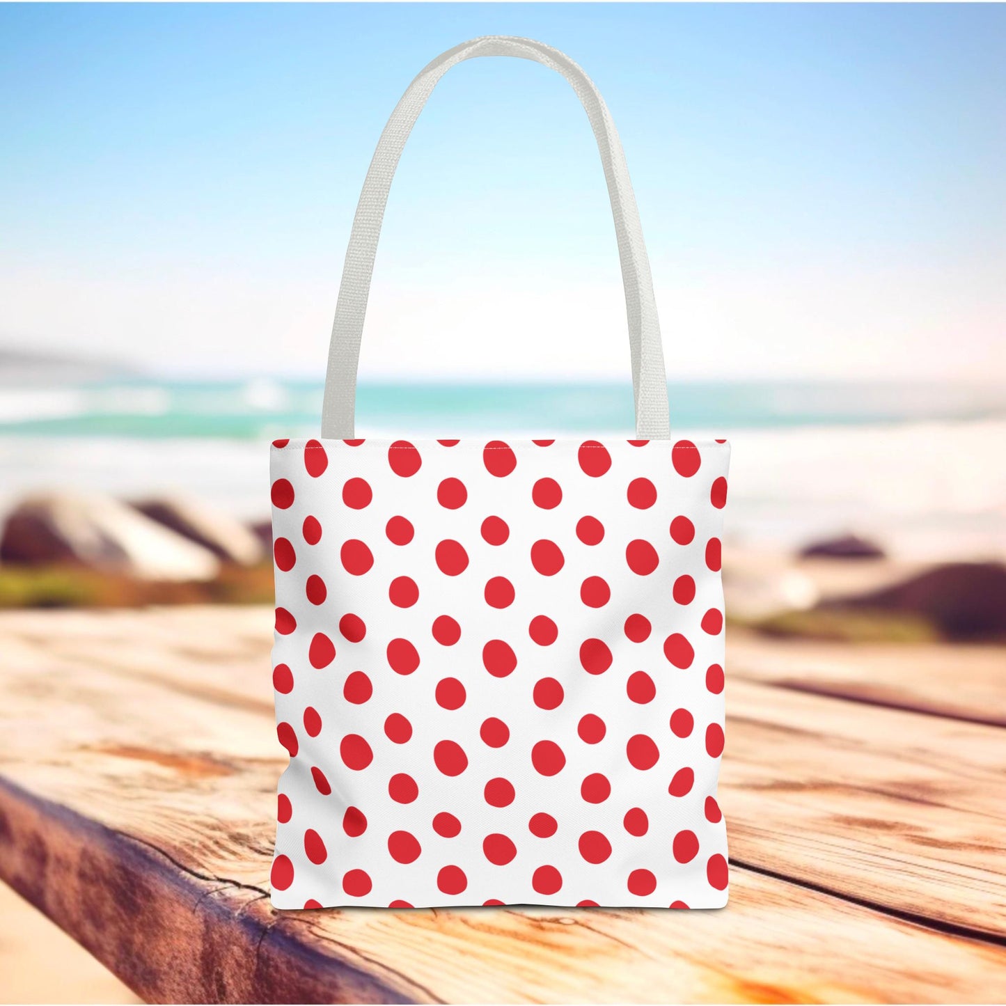 Red Polka Dots Tote Bag with a playful design sits on a wooden table, perfect for errands or beach outings. A durable, stylish accessory from FireBrook Designs, enhancing daily life with joy.