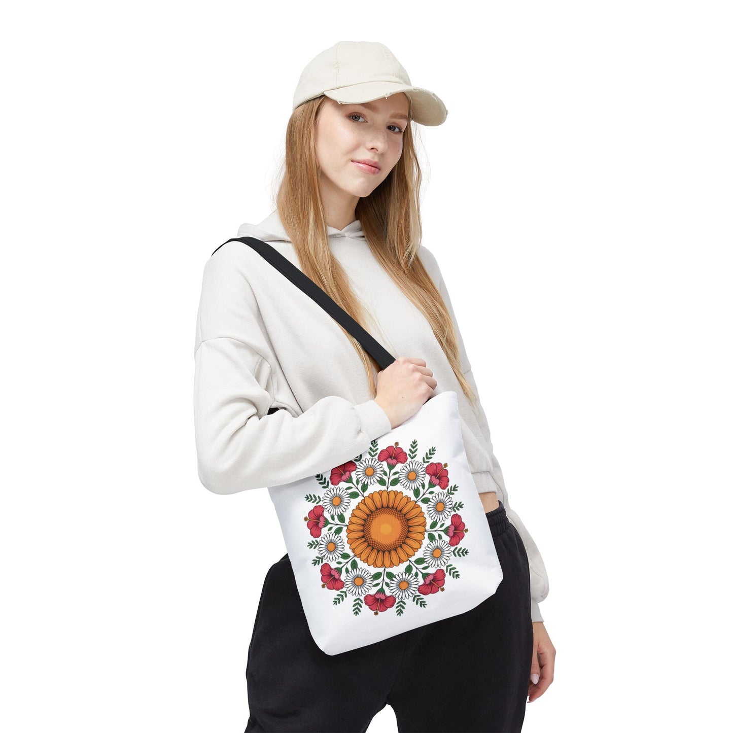 Mandala Sunflowers & Daisies Tote Bag: Young woman models a white canvas tote adorned with a sunflower-centered mandala, encircled by daisies and poppy-like flowers, showcasing a boho-chic style.
