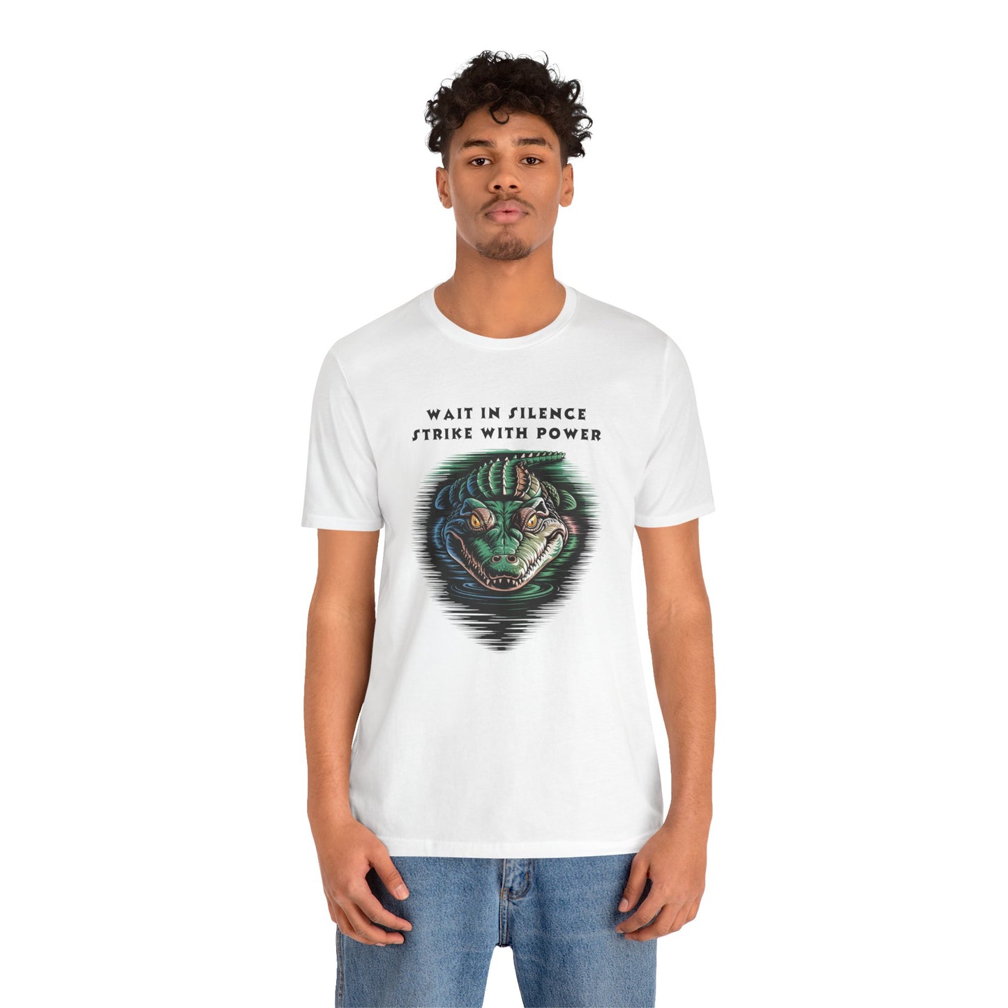 Crocodile: Walk in Silence, Strike with Purpose Bella+Canvas Unisex T-Shirt featuring a bold cartoon crocodile face design, worn by a man in jeans, embodying stealth and determination.