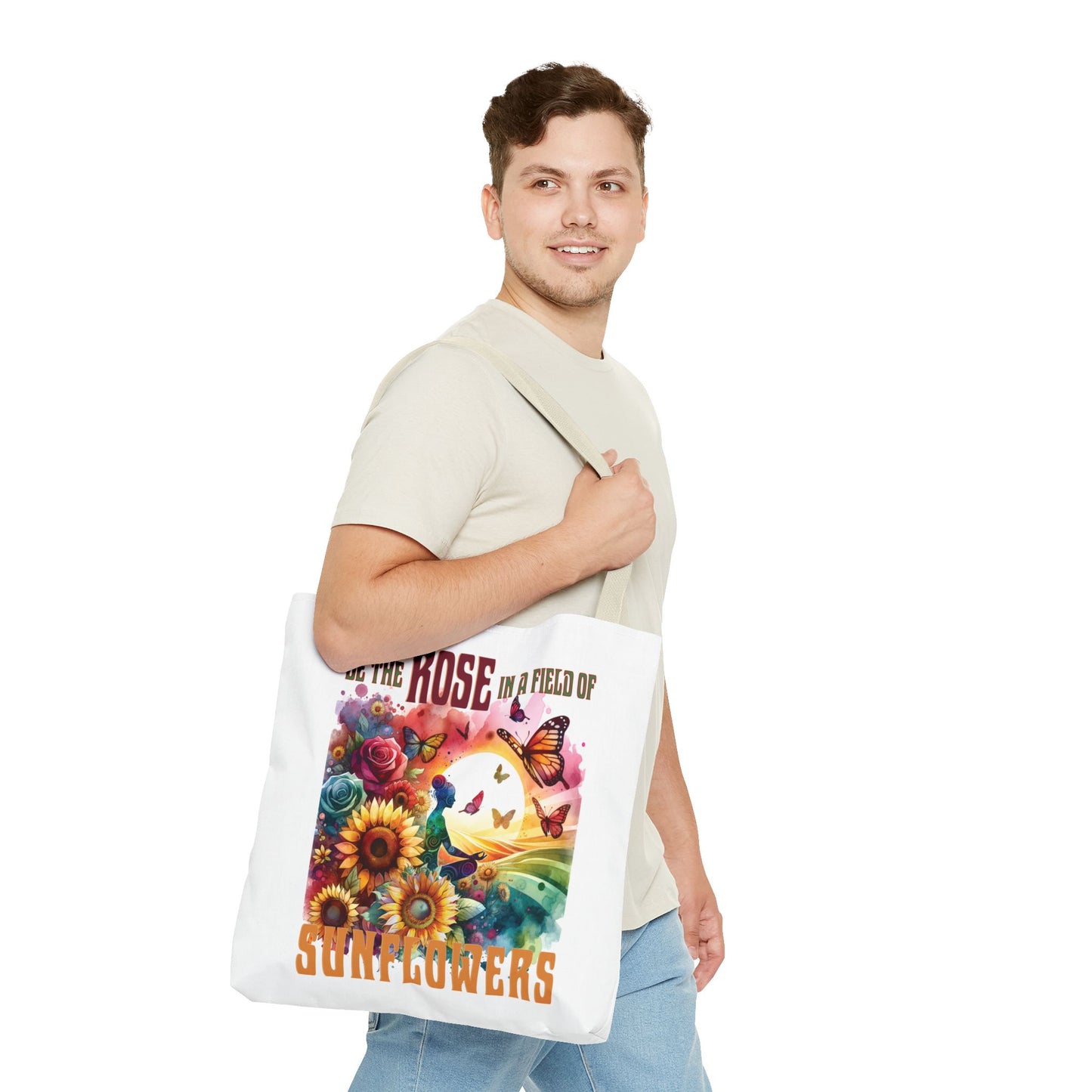 Man holding Be the Rose in a Field of Sunflowers tote bag, featuring flower and butterfly design, highlighting nature-inspired positivity.