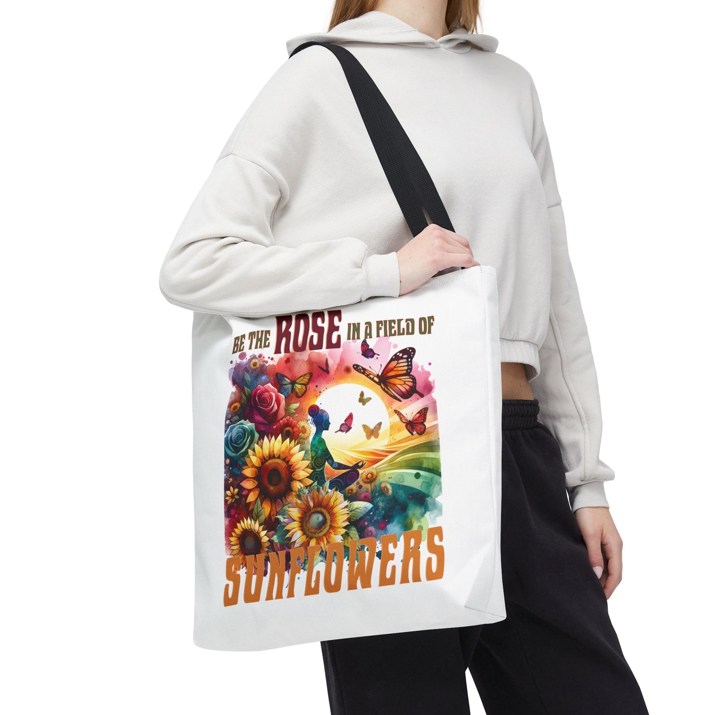 Be the Rose in a Field of Sunflowers Tote Bag held by a woman, featuring a unique design with a woman and butterflies. Ideal for everyday use.