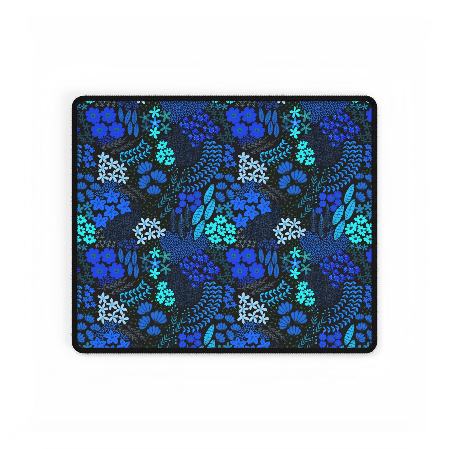 Blue Floral Desk Mat featuring a dark background with hand-drawn blue and teal botanical patterns, edged with a stitched black border. Ideal for adding elegance and style to your workspace.