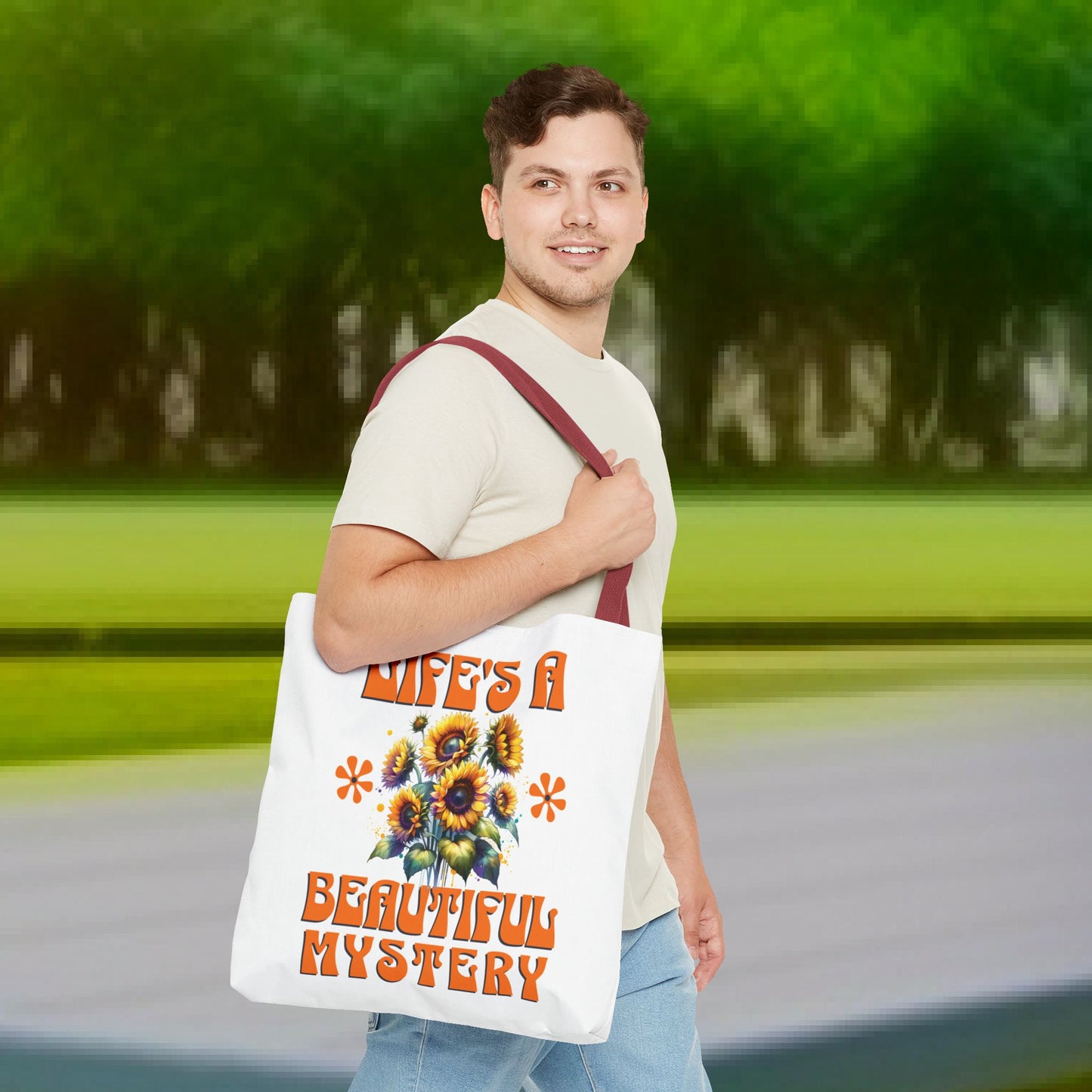 Man holding the Life's A Beautiful Mystery Tote Bag, featuring a floral design. Ideal for those drawn to exploration and life's surprises.