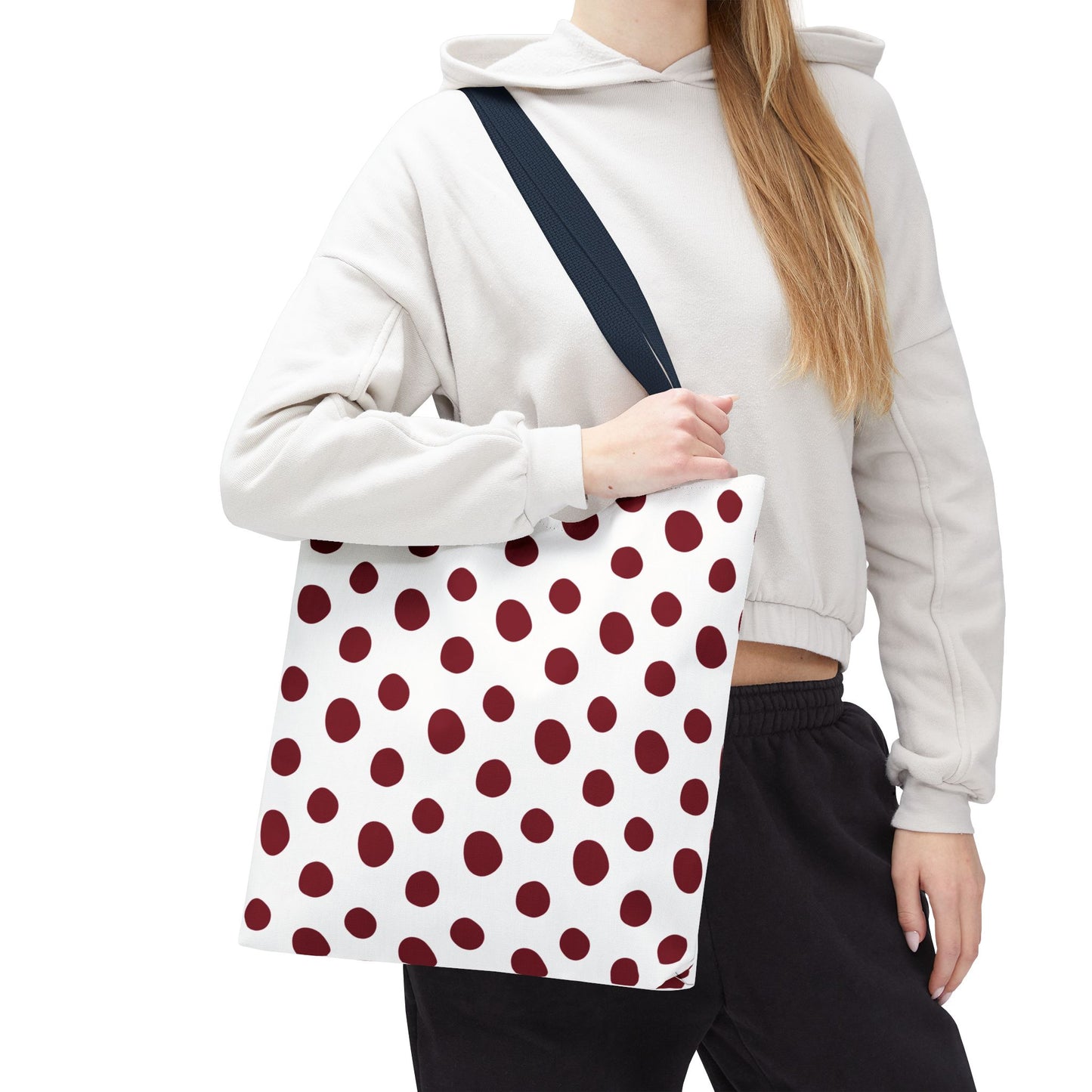 Burgundy Polka Dots Tote Bag held by a woman, showcasing its stylish red and white design, durable polyester fabric, and reinforced handles, perfect for everyday use and adding a classic touch to any outfit.