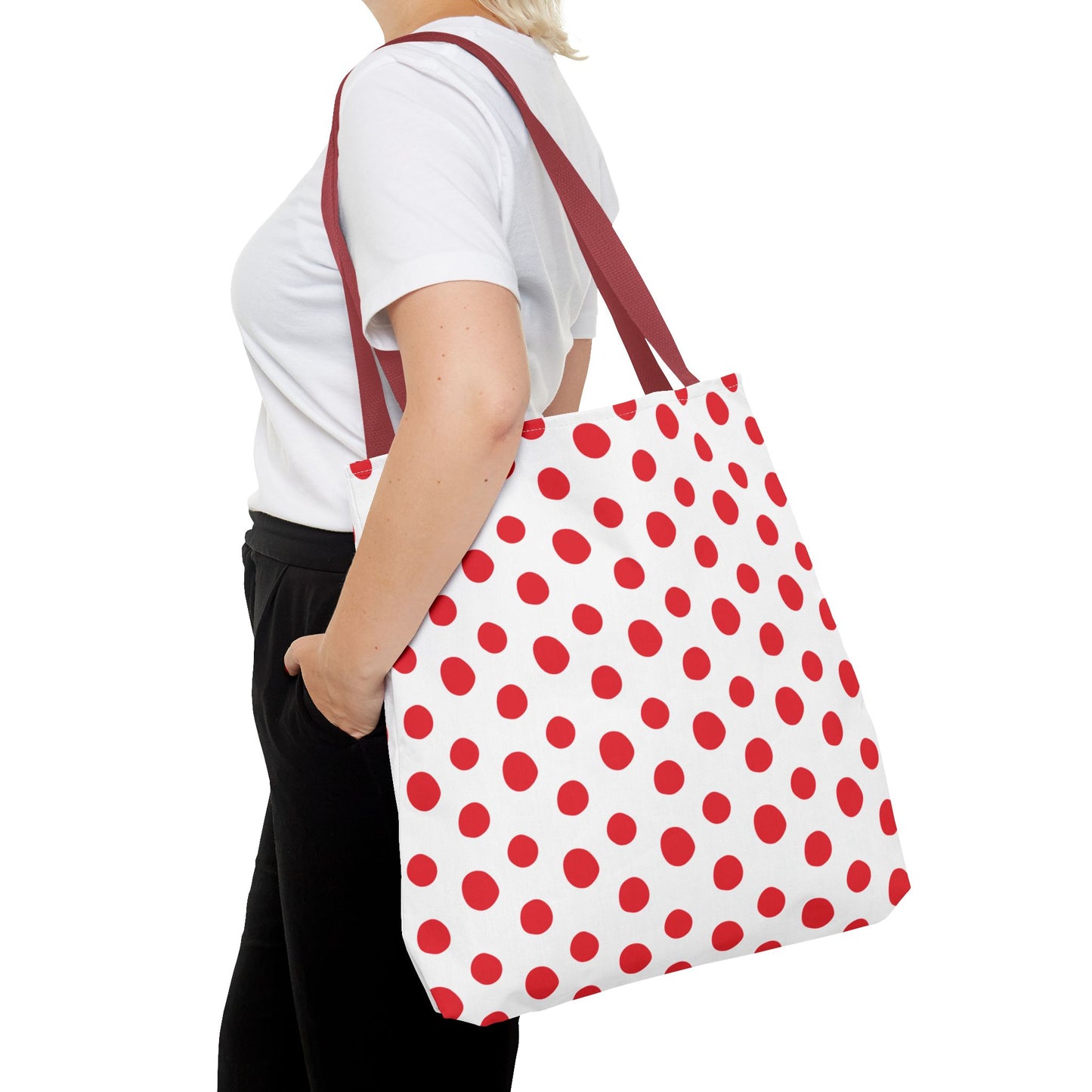 Red Polka Dots Tote Bag held by a woman, showcasing a playful design ideal for errands or beach trips, with durable 100% polyester and reinforced handles for everyday use.
