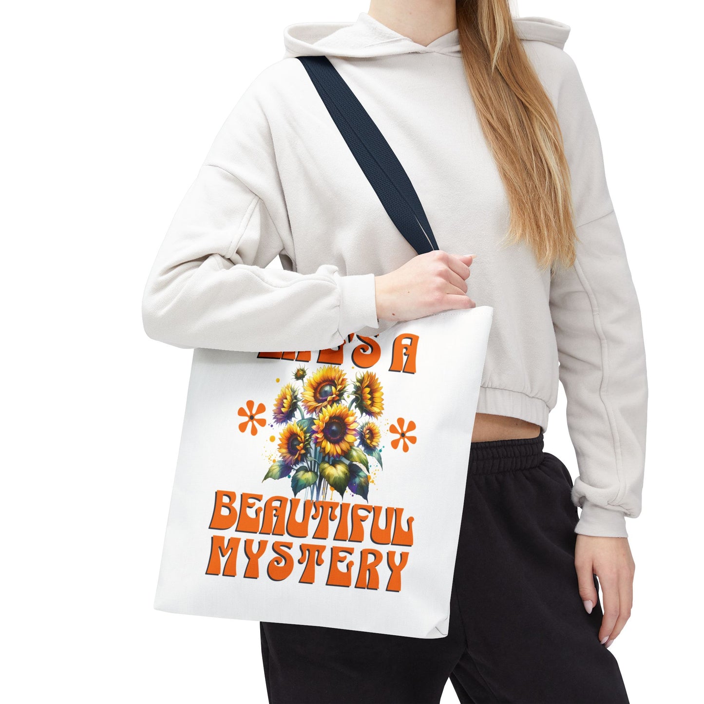 Life's A Beautiful Mystery Tote Bag held by a woman, featuring durable polyester, reinforced handles, and boxed corners, perfect for daily adventures and exploring life's surprises.