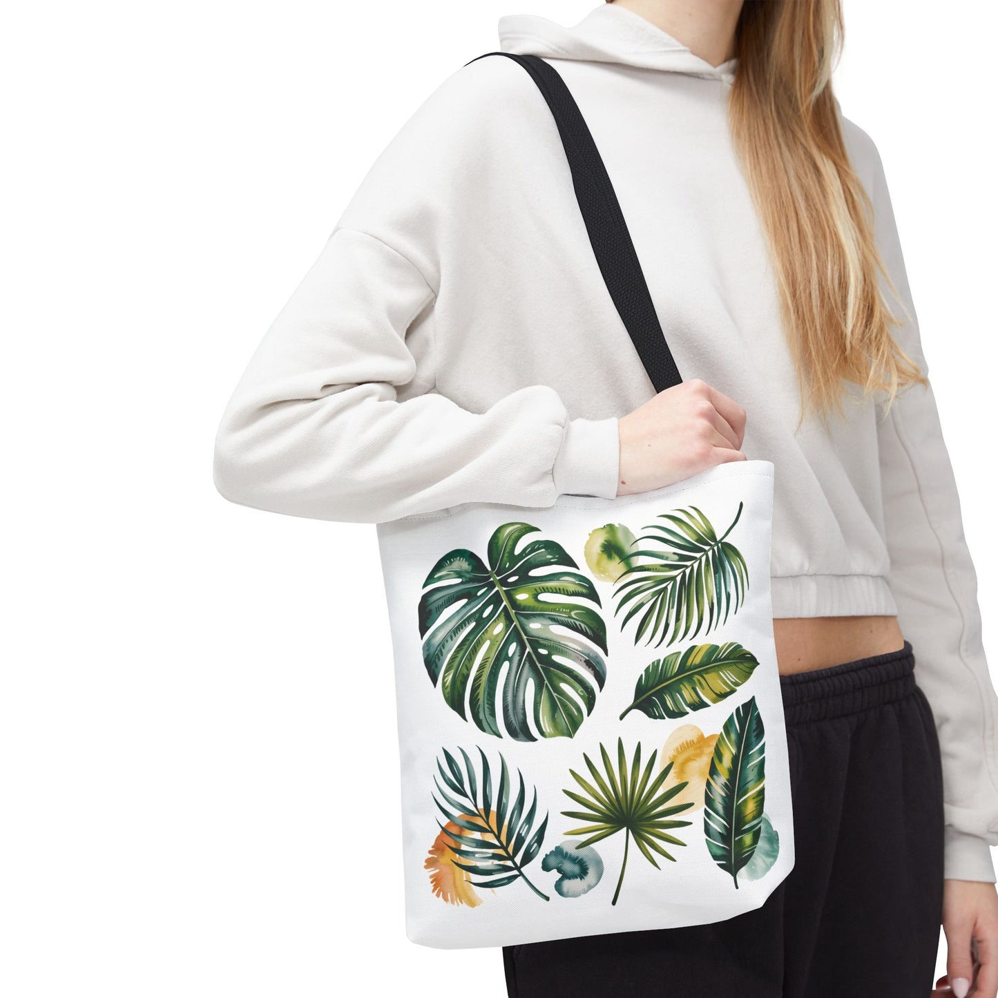Tropical Leaves Tote Bag featuring a hand holding a leaf-patterned section, highlighting its spacious and durable design, ideal for beach or casual use, embodying FireBrook Designs' stylish and uplifting essentials.