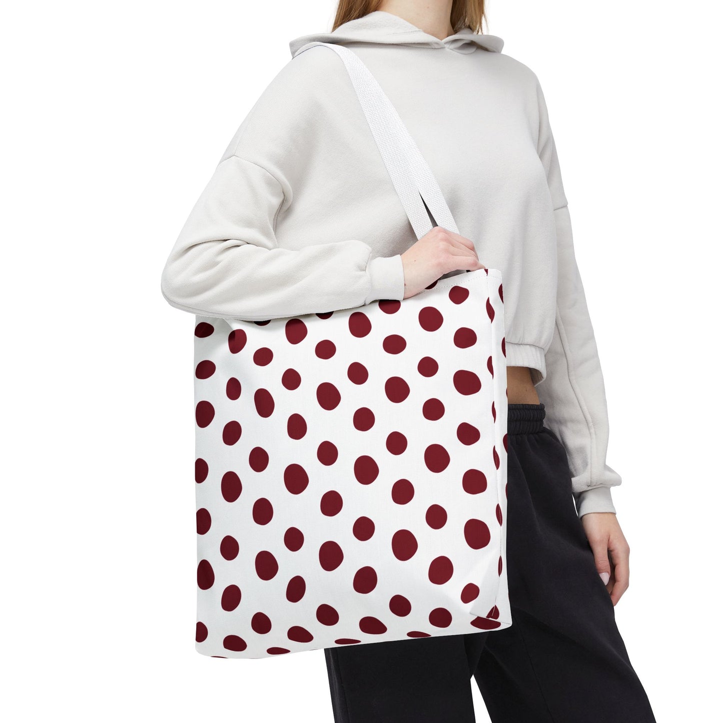 Burgundy Polka Dots Tote Bag showcased against skin, emphasizing its stylish polka dot pattern and durable polyester fabric, perfect for everyday use, aligning with FireBrook Designs' commitment to joy and practicality.