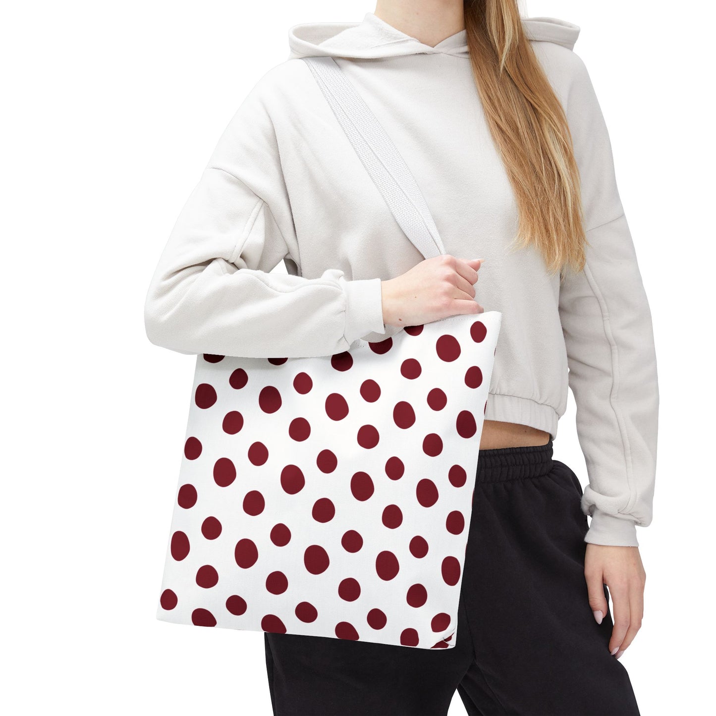 Burgundy Polka Dots Tote Bag held by a woman, showcasing its stylish red and white polka dot pattern. Ideal for everyday use with reinforced handles, reflecting FireBrook Designs' commitment to functional, joyful accessories.