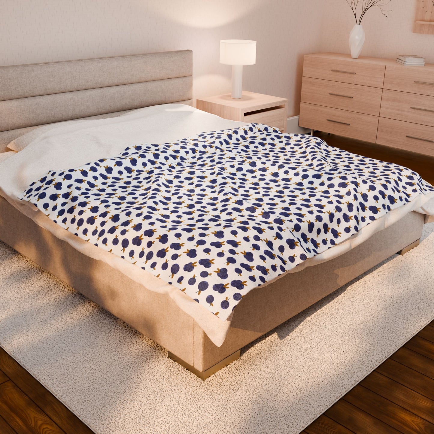 Plush Blanket - Blueberry Pattern draped over a bed, showcasing its cozy texture and elegant design, complemented by a nearby white vase with a branch and a white lamp shade.