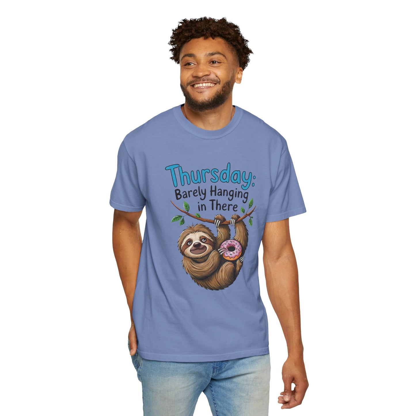 Man wearing Thursday: Barely Hanging In There Sloth Graphic Comfort Colors Unisex T-Shirt, featuring a sloth holding a donut, smiling casually. Ideal for sloth lovers and casual, stylish comfort.