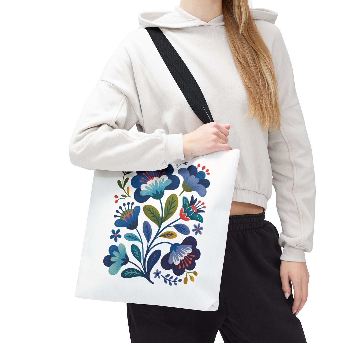 Vintage Folk Art Design Blue Floral Tote Bag showcasing a charming vintage floral pattern. Perfect for everyday use or special occasions, offering durability with a 100% polyester body, reinforced handles, and boxed corners.