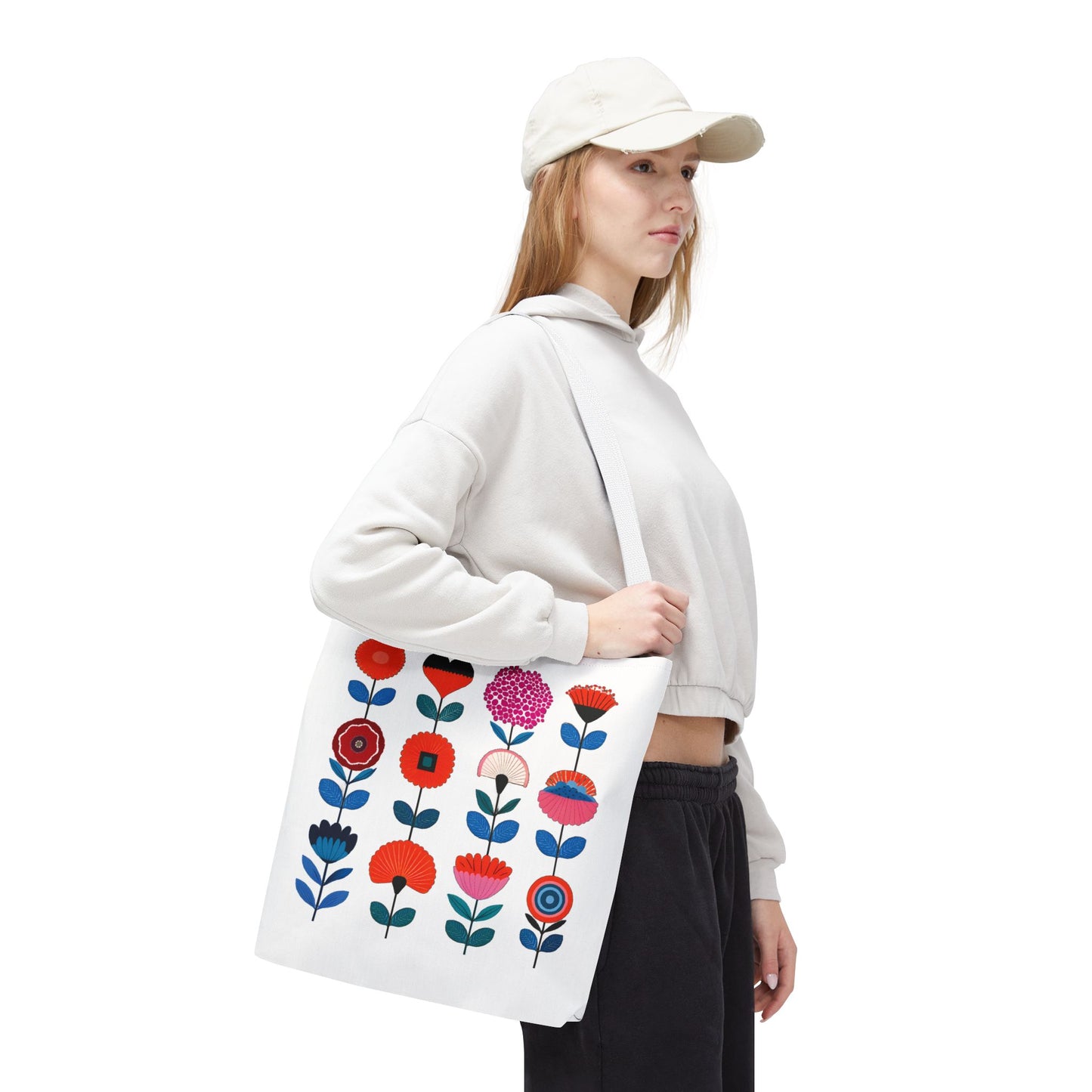 Woman in white hat holding a Floral Pattern Tote Bag with flower design, embodying spring charm and functionality from FireBrook Essentials.
