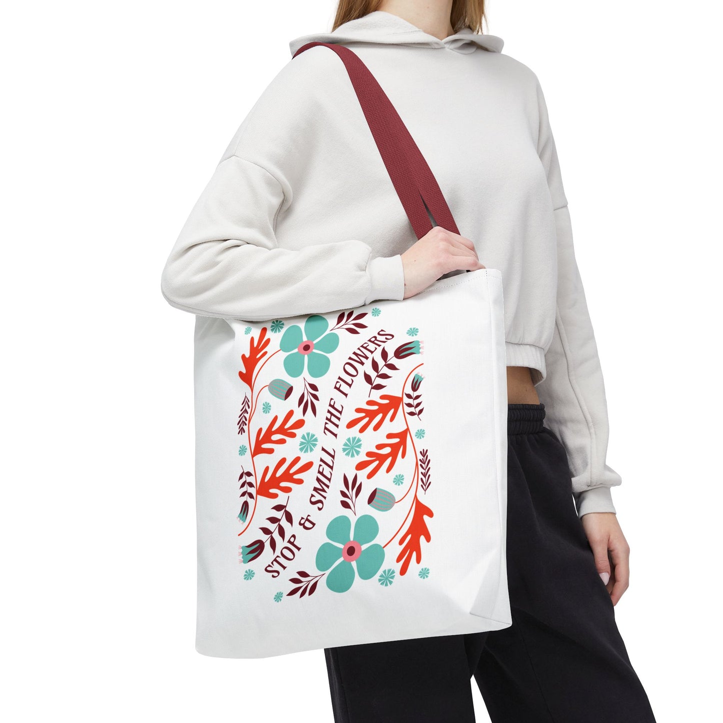 Stop and Smell The Flowers Tote Bag, featuring a floral design and red strap, held by a woman, ideal for carrying essentials with a touch of nature.