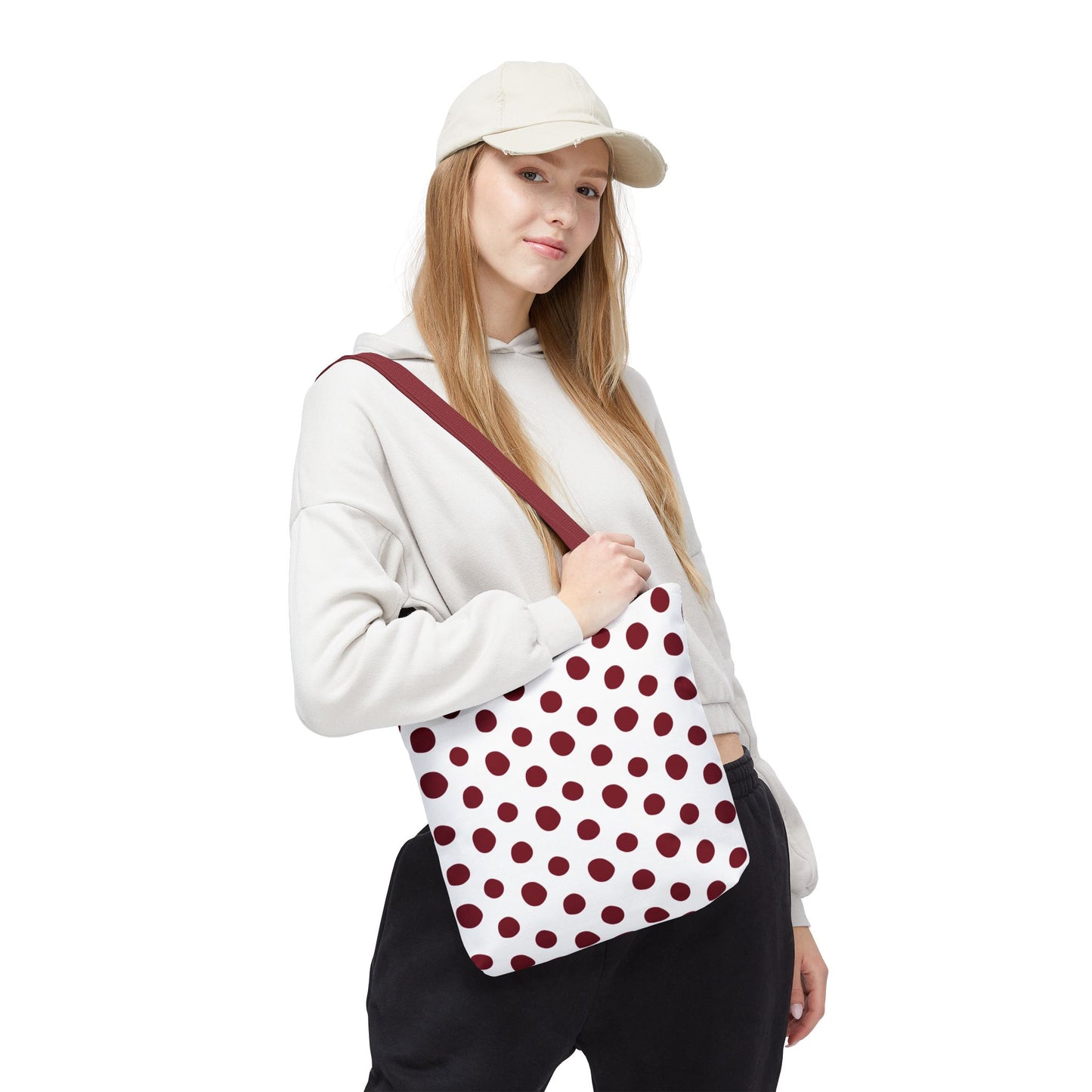 Burgundy Polka Dots Tote Bag held by a hand, showcasing its durable polyester fabric and reinforced handles, perfect for everyday use. A stylish accessory embodying FireBrook Essentials' commitment to comfort and joy.