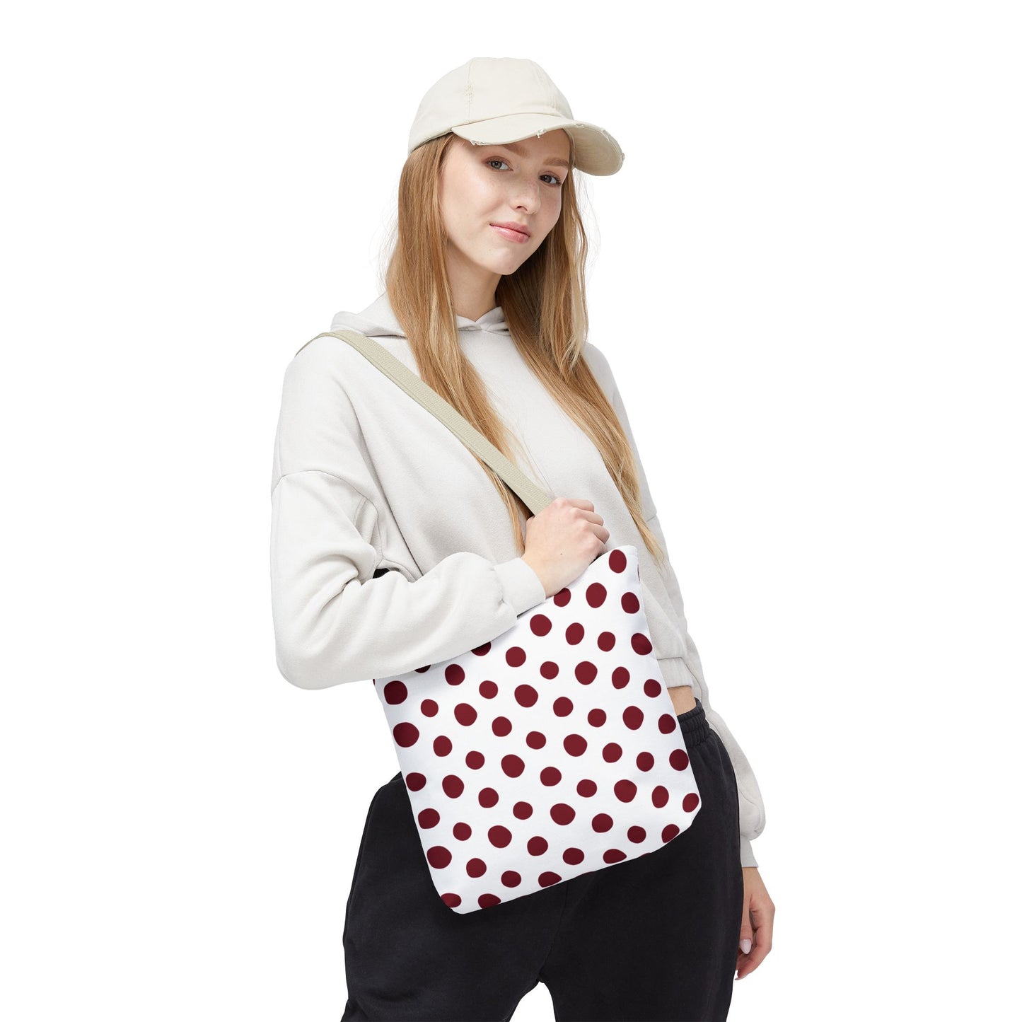 Burgundy Polka Dots Tote Bag showcased next to a woman wearing a hat. The tote bag's durable polyester fabric and reinforced stitching are ideal for everyday use, combining style and function.