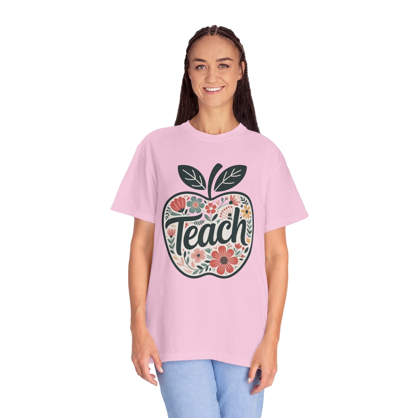 Floral Apple TEACH T-shirt featuring a hand-drawn pastel floral apple design with TEACH in textured script, offering a whimsical touch. Ideal for educators, emphasizing comfort and style.
