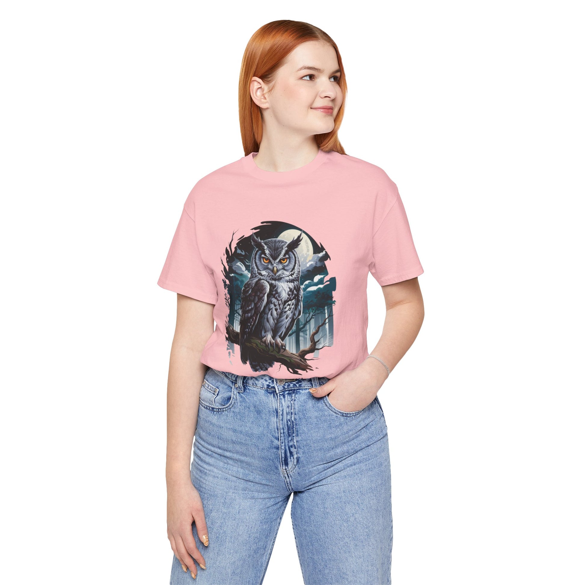 The Gray Owl: Hunt in Silence Bella+Canvas Unisex T-Shirt features an owl print on a pink shirt, modeled by a woman in jeans, embodying FireBrook Essentials' stylish, comfortable ethos.