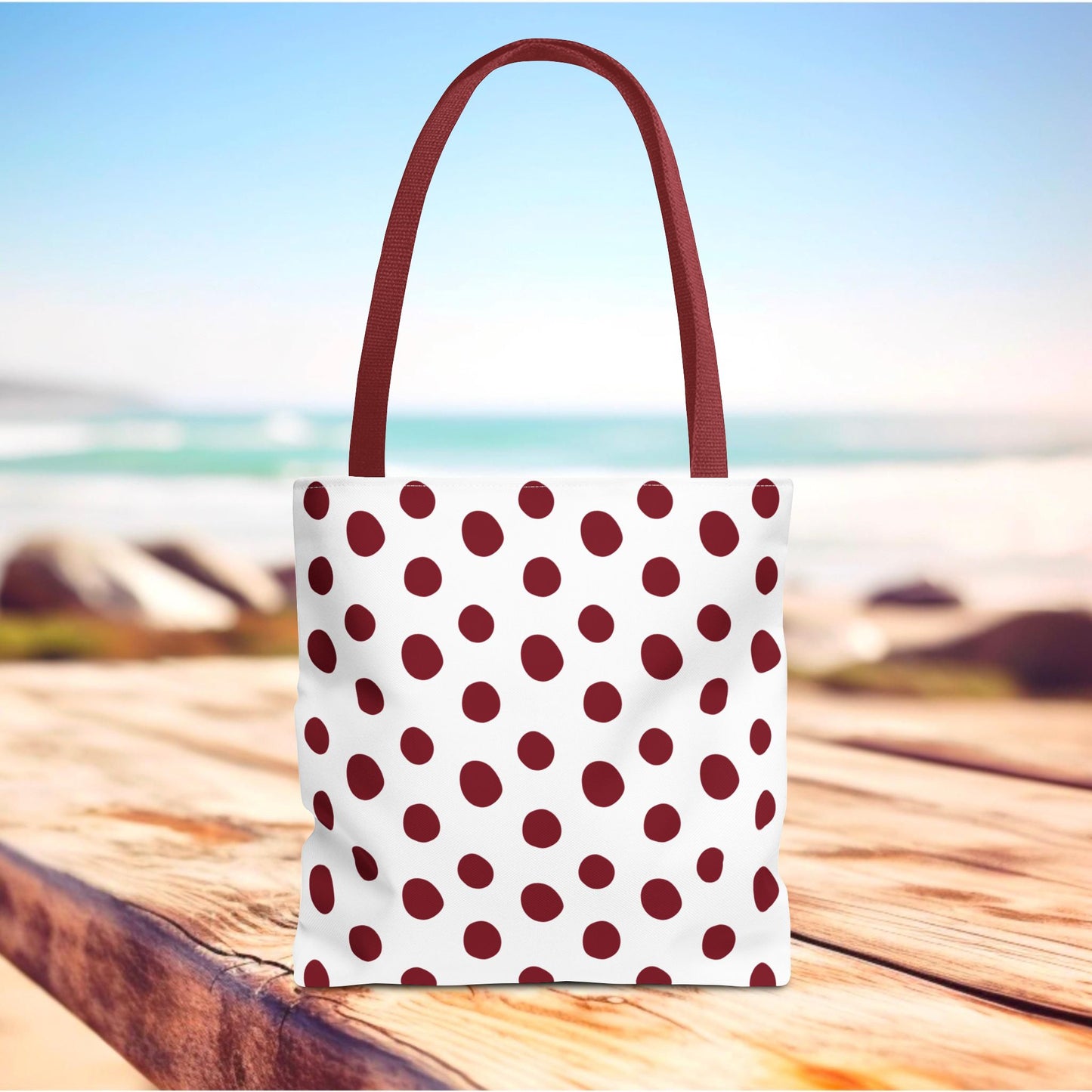 Burgundy Polka Dots Tote Bag on a wooden table, featuring a stylish polka dot pattern and reinforced handles, embodying FireBrook Essentials' blend of comfort and style for everyday use.