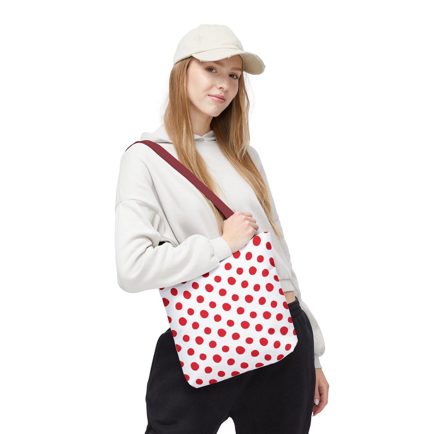 Red Polka Dots Tote Bag with playful design, shown being held by a woman, features durable polyester, seamless finish, reinforced handles, available in multiple sizes, ideal for errands or festive occasions.