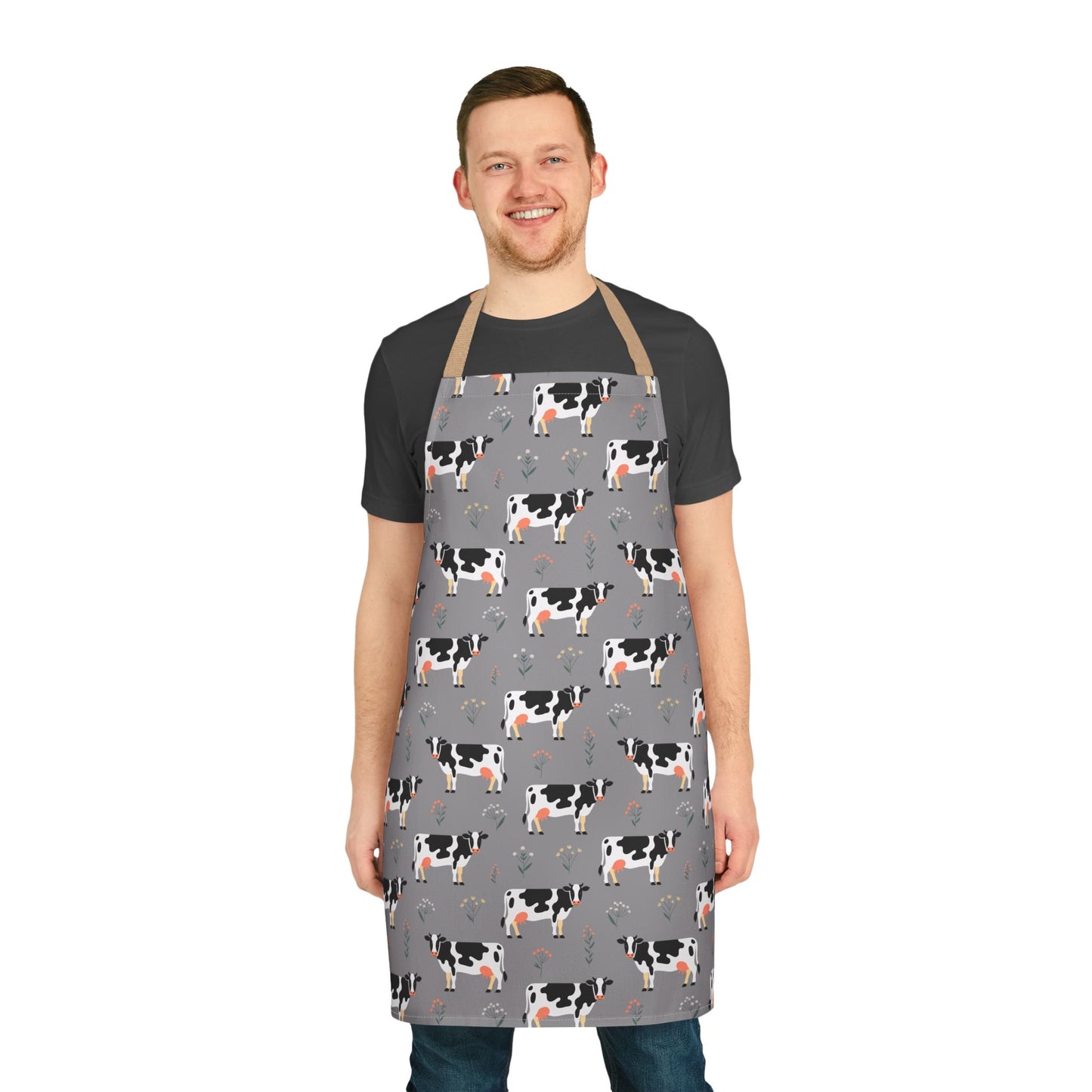 Man wearing an apron with a Holstein dairy cows pattern, showcasing the Apron Dairy Cows Pattern from FireBrook Designs, perfect for cooking, baking, and crafting enthusiasts seeking a farm-inspired vibe.