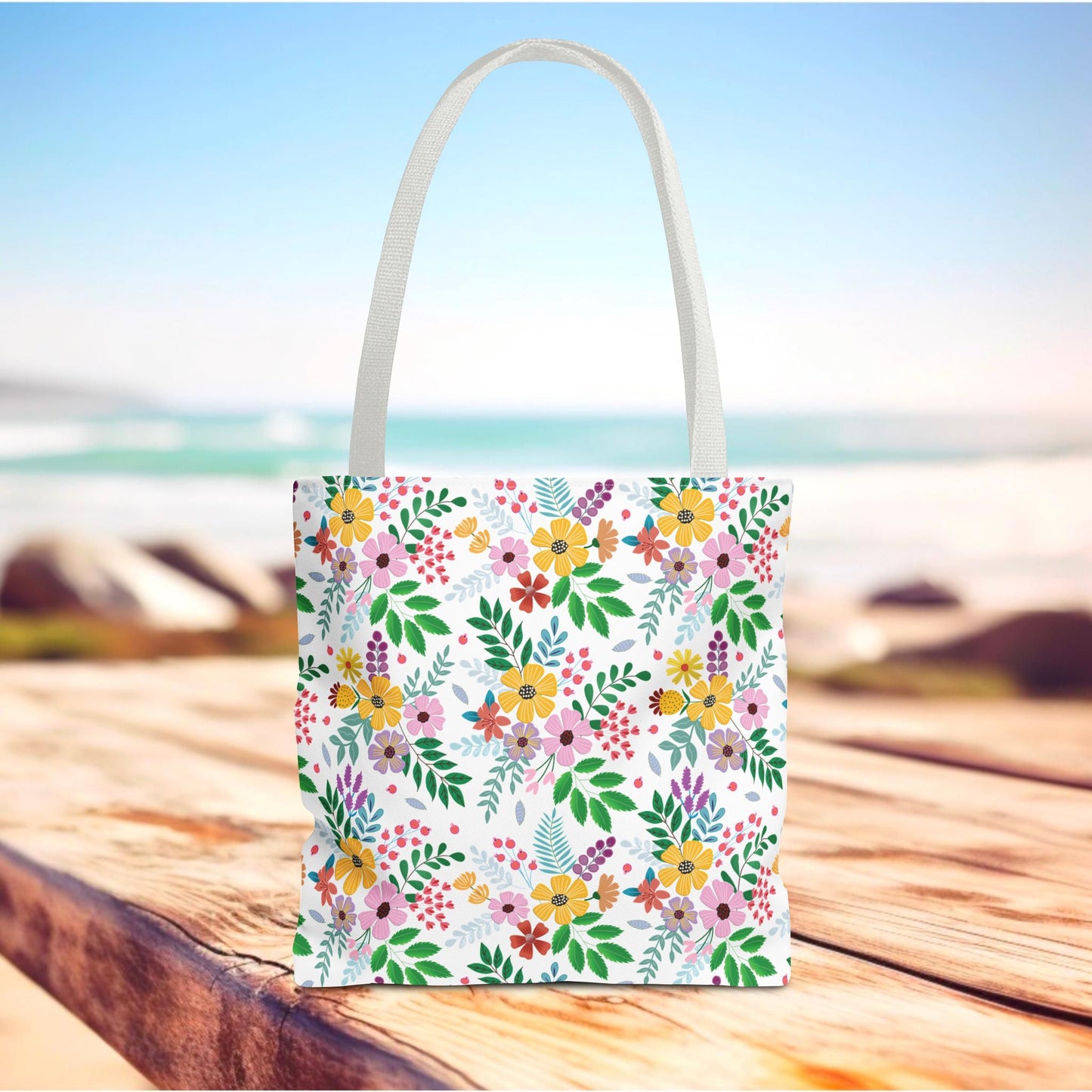 Floral Tote Bag on a wooden surface, featuring vibrant floral patterns. Ideal for summer outings, it embodies FireBrook Essentials' uplifting style, combining durability and cheerfulness for joyful, practical use.