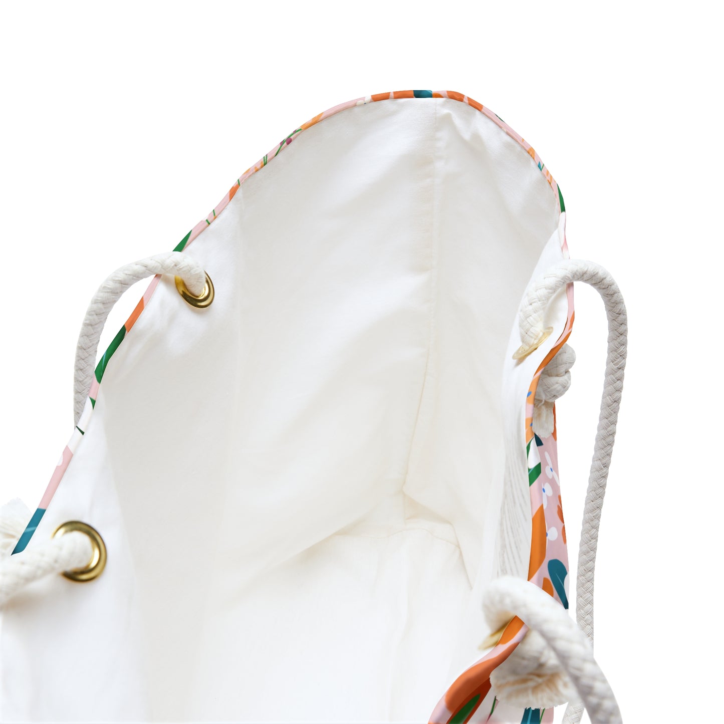 Weekender Bag with braided rope handles threaded through brass grommets reveals a white interior lining. Designed for stylish travel, it features a colorful printed exterior edge and ample storage space.