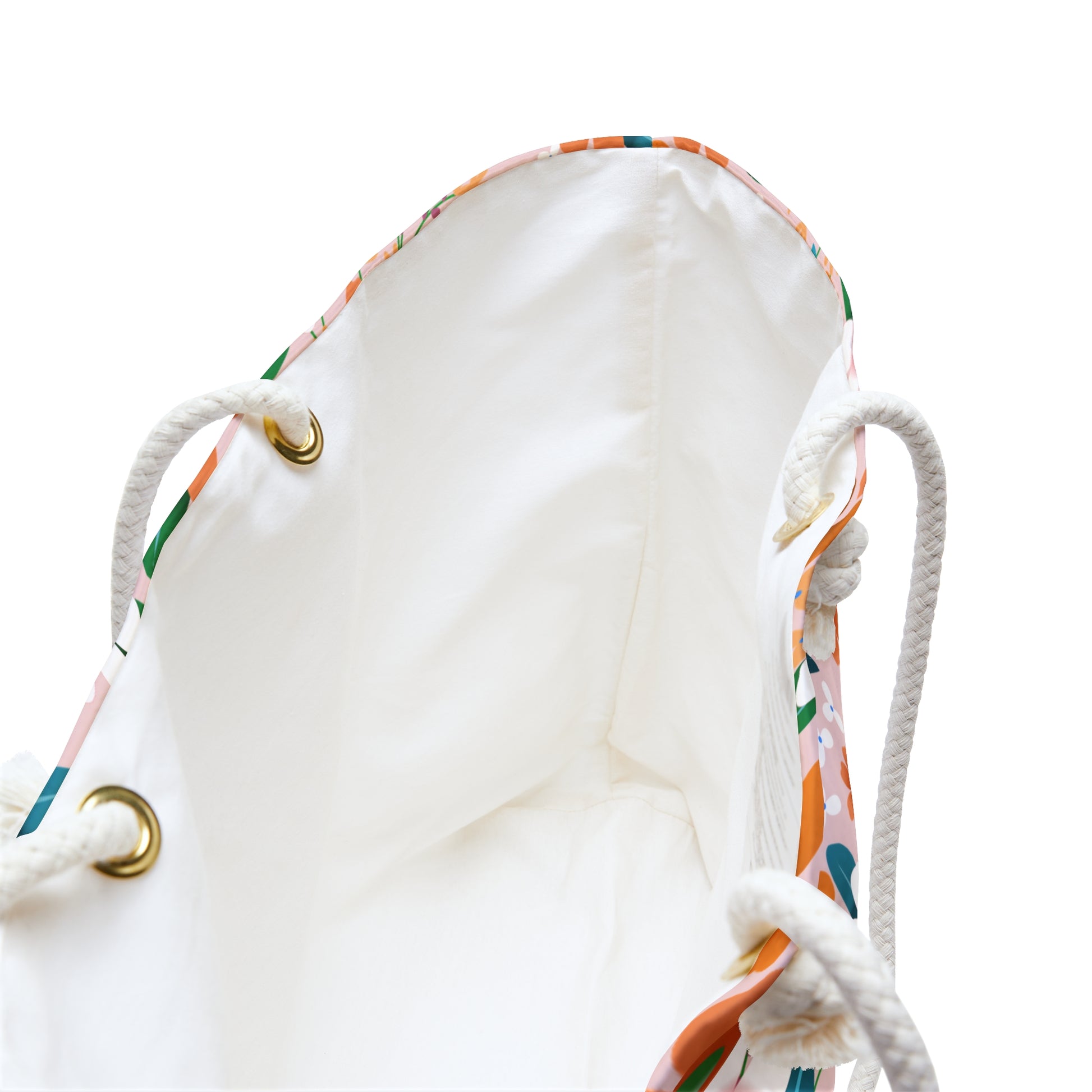 Weekender Bag with braided rope handles threaded through brass grommets reveals a white interior lining. Designed for stylish travel, it features a colorful printed exterior edge and ample storage space.