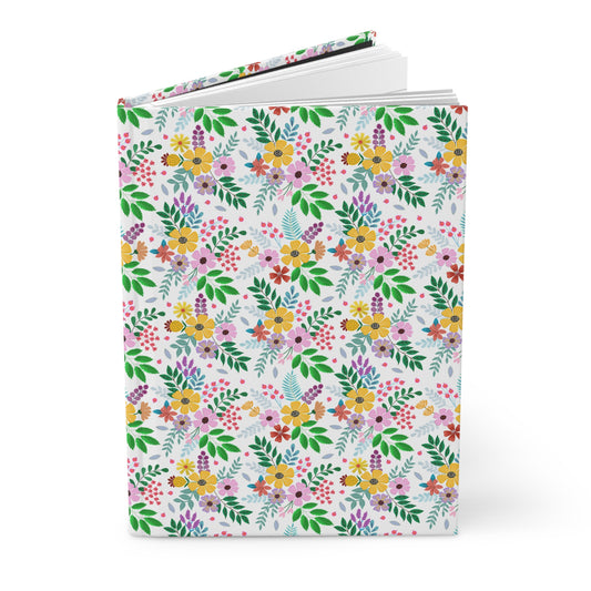 HARDCOVER JOURNAL, MATTE, RULED, 5X7, SEWN BIND, CLEAN-TEAR PAGES – BOTANICAL BURST, featuring a seamless floral pattern on the cover, stands upright, showcasing its smooth, durable finish and crisp white interior pages.