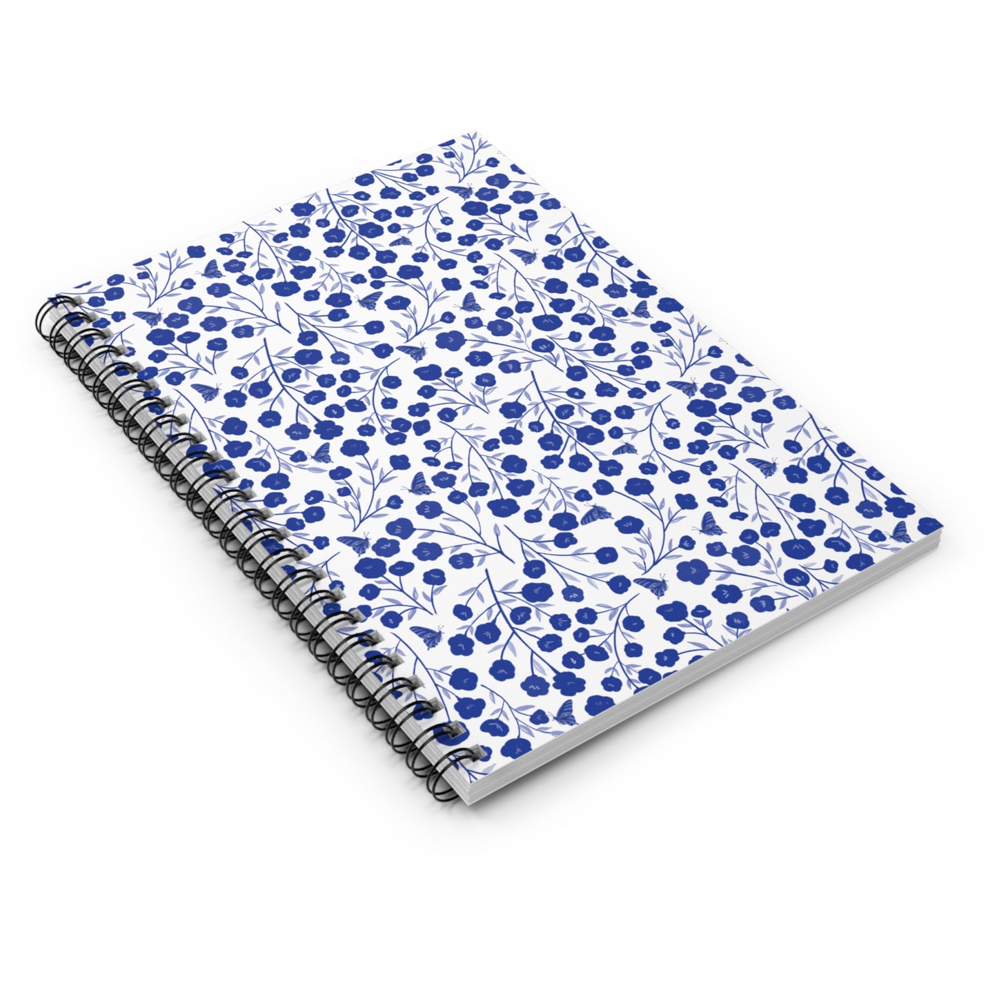 Floral Spiral Notebook with blue floral pattern on white cover, black metal coil binding, ideal for capturing thoughts, sketching, and organizing, reflecting FireBrook Essentials' style and positivity.