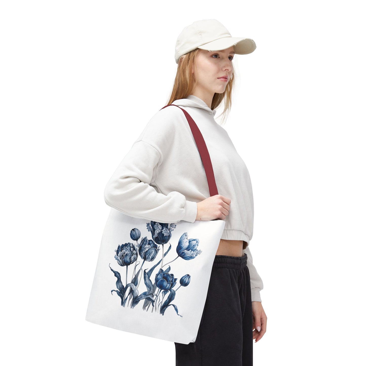 Woman in white hat holds Flowers in Blue Hue watercolor tote bag, showcasing its floral design and practical style for everyday use.