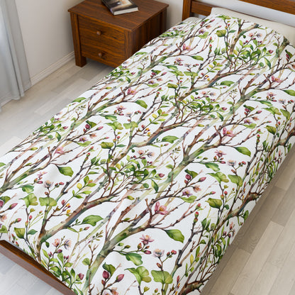 Plush Blanket - Blooming Forest Floor Design, showcasing a serene pattern of budding trees and flowers on a bed, reflecting nature's beauty and comfort, ideal for cozy, nature-inspired relaxation.
