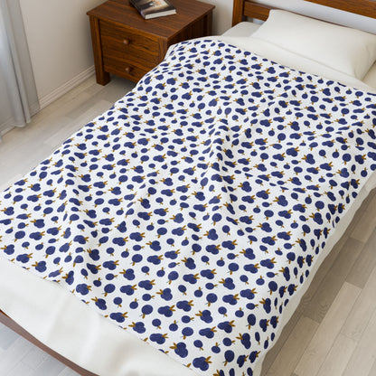 Plush Blanket - Blueberry Pattern draped over a bed, showcasing its cozy and inviting design, ideal for adding a touch of comfort and style to any bedroom setting.
